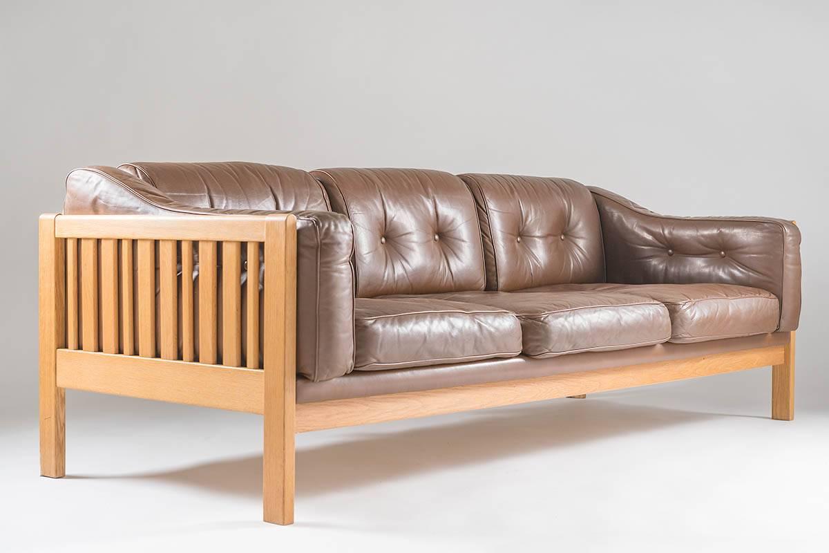 Top-quality sofa designed by Ingvar Stockum for Futura Möbler in 1965. This sofa was only in production for two years because production costs were too high. The sofa is made of solid oak, and leather cushions filled with polyethylene.
This sofa is