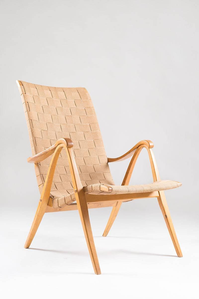 A rare armchair made of birch and linen webbing by unknown Swedish designer. This chair is designed with a great sense for proportions and quality. The legs that are made of one piece support the armrests, making it look as if they are resting on