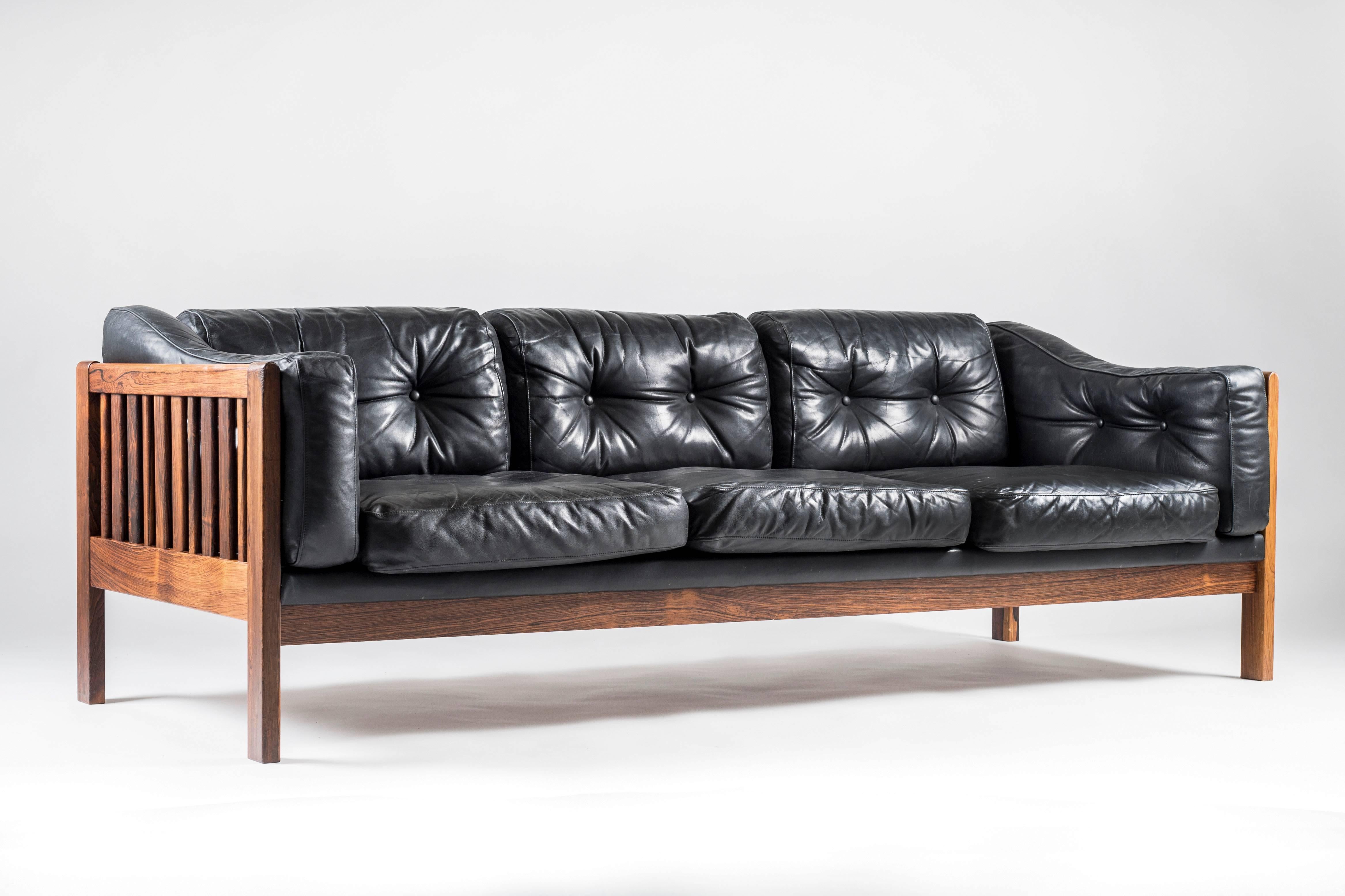 Top-quality sofa designed by Ingvar Stockum for Futura Möbler in 1965. This sofa was only in production for two years because production costs were too high. This luxury version with its frame made of solid rosewood and black leather cushions filled