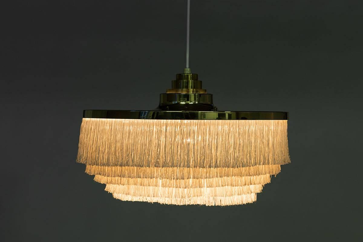 Ceiling light with brass frame and white silk fringes by Hans-Agne Jakobsson for Markaryd in Sweden, from the Scandinavian Mid-Century Modern era. The lamp is in very good condition, with only small signs of age and use. The fringes have been cut