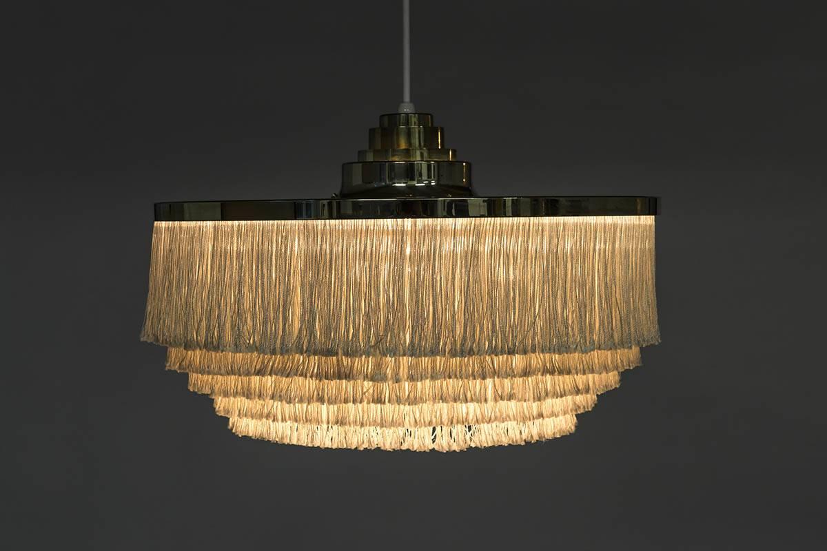 Ceiling light with brass frame and white silk fringes by Hans-Agne Jakobsson for Markaryd in Sweden, from the Scandinavian, Mid-Century Modern era. 
The lamp is in very good condition, with only small signs of age and use. It has been rewired and