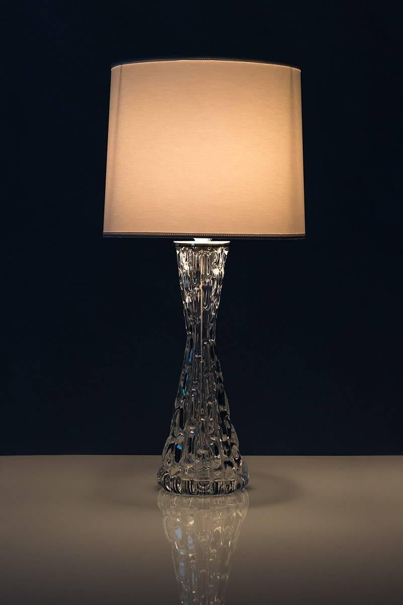 A pair of impressive table lamps in crystal glass model RD 1477 by Carl Fagerlund for Orrefors, Sweden. The base is made of crystal glass and reminds of frozen water. The chrome details add to the feeling of Frost and ice that is significant for the