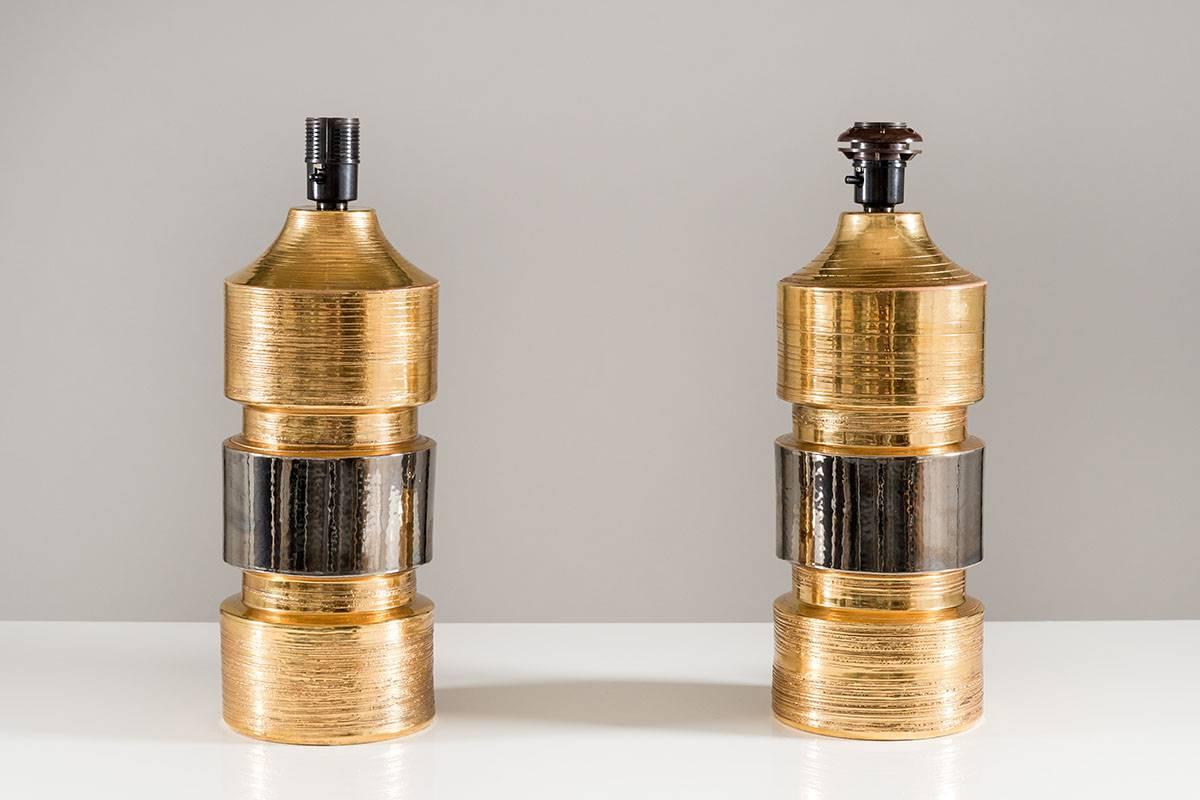 Pair of table lamps by Bitossi for Swedish manufacturer Bergboms. 
These impressive lamps are made of gold and silver glazed ceramic. 
Please note that the lamps are sold without shades.
Height without shades: 37cm
Condition: Good original