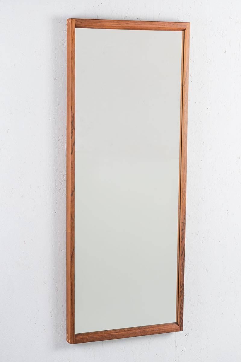Rectangle mirror No 145K in rosewood by Aksel Kjersgaard, Denmark. This mirror is of a great quality in construction and has beautiful details, such as the visable wooden plugs on the edges. 
Condition: Excellent, slightly sun bleached.