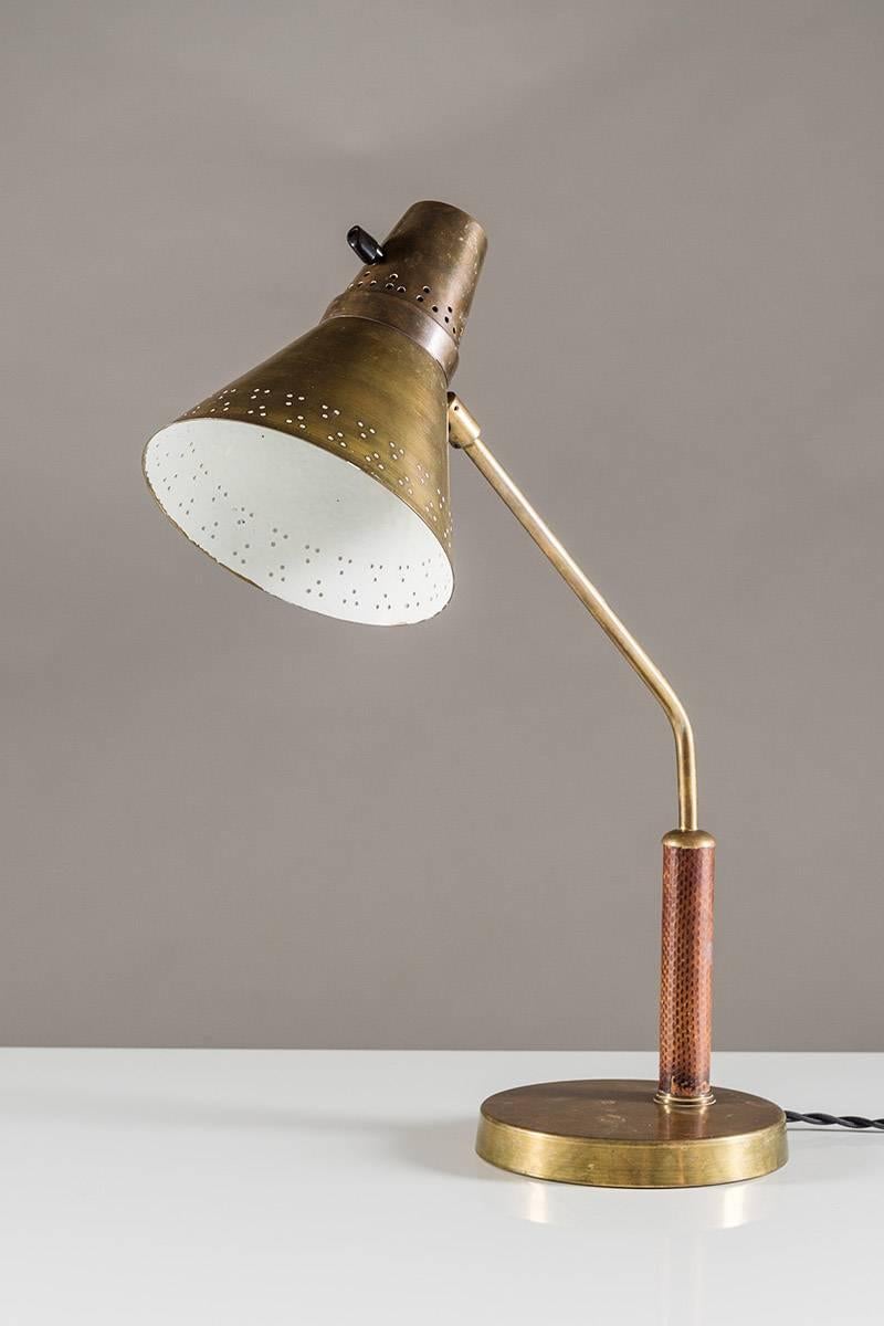 Beautiful desk lamp by Swedish manufacturer AB E. Hansson & Co., circa 1940. The shade is made of brass with perforations around the edge, giving a beautiful light. The shade is fixtured on a brass stem and is adjustable in any direction. The brass