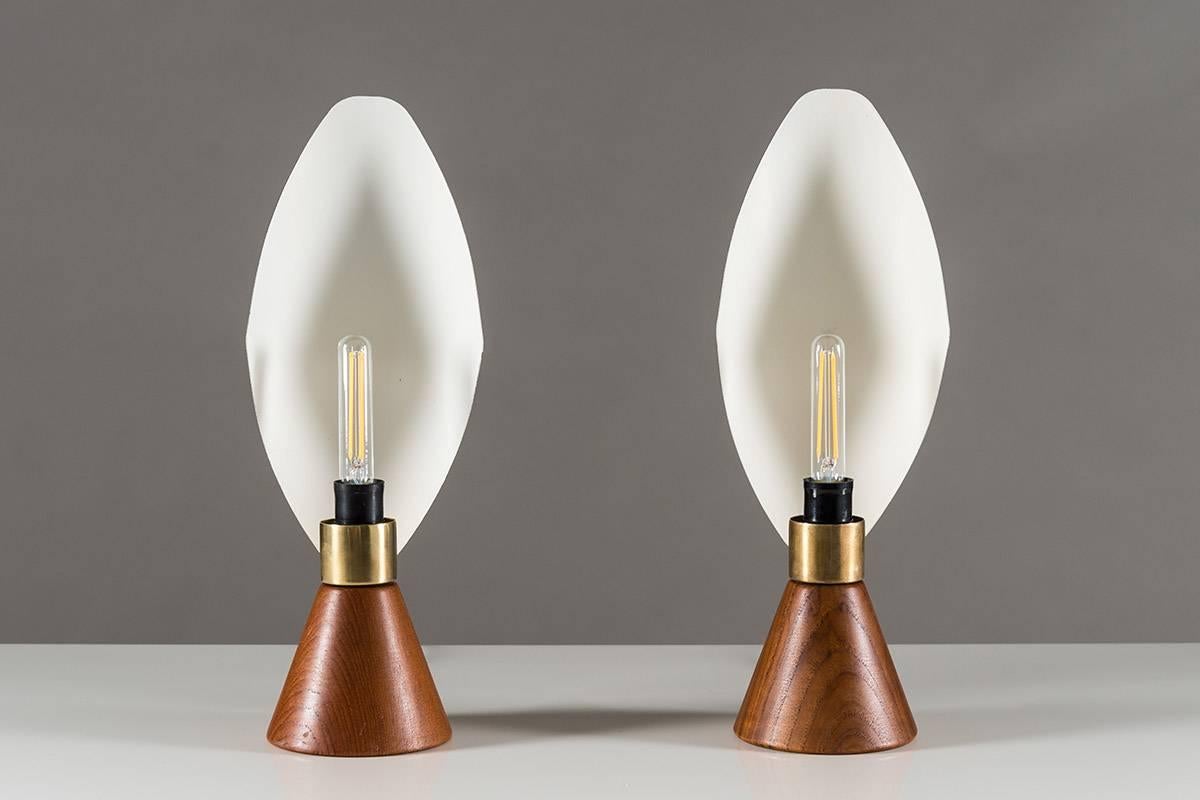 Pareja de lámparas de mesa escandinavas de Svend Aage Holm Sørensen, de la época moderna de mediados de siglo. Raro modelo con base de teca unida a un reflector metálico de bella forma.
Estado de conservación: Estado muy original, pero le faltan las