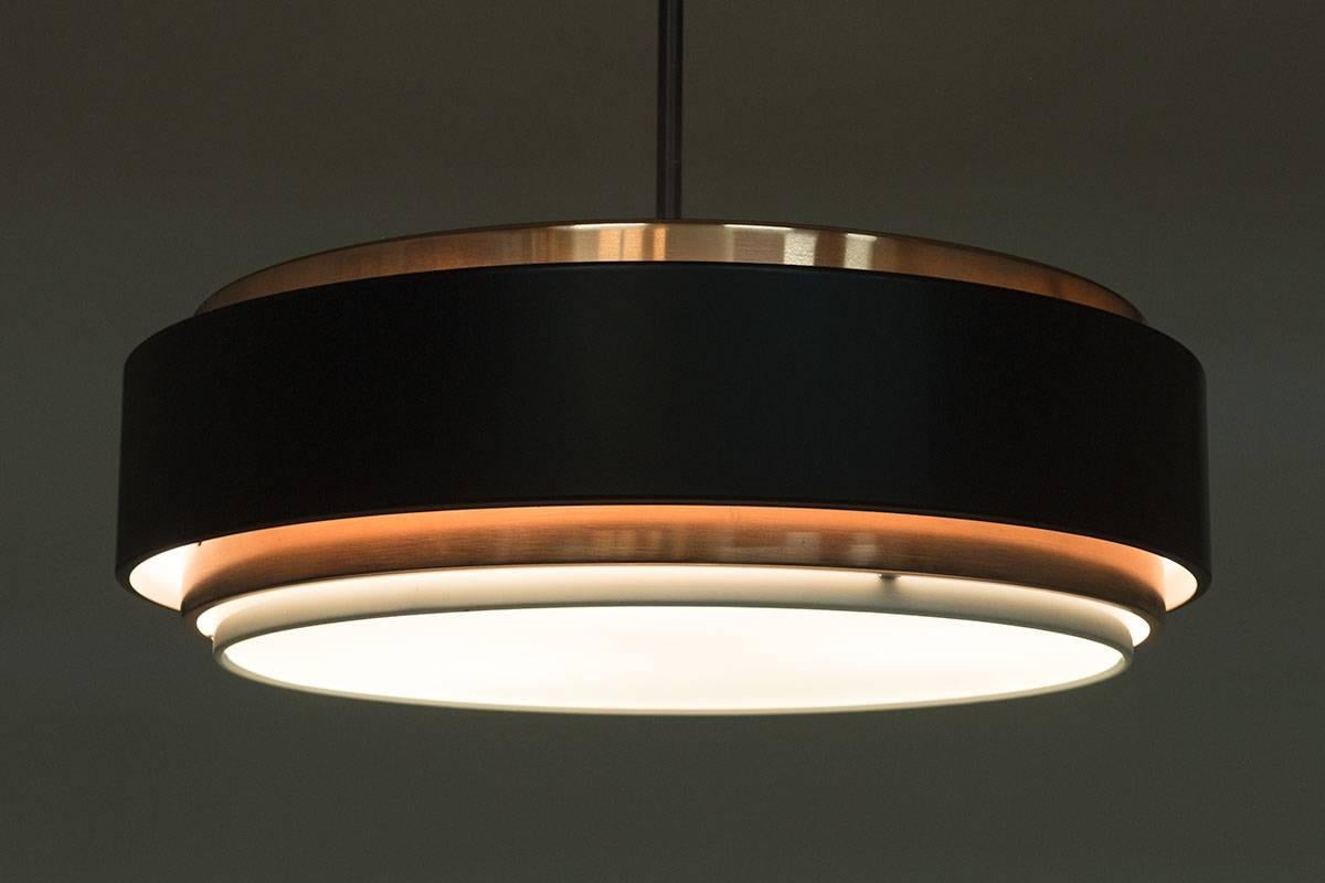 A Danish midcentury pendant by Jo Hammerborg for Fog & Mørup. The pendant features three-light sources fitting E-27 bulbs, giving a warm cozy light.

Condition: Excellent restored condition. The copper parts have been polished and the plastic