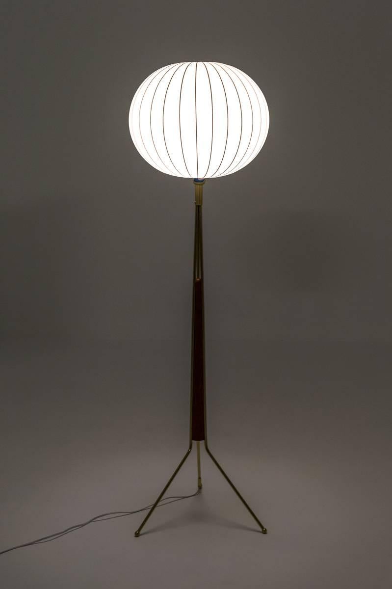 Tripod floor lamp in brass and teak by Möllers Armaturfabrik, Sweden. 
This rare model is made of a teak base held by three brass legs. It has a large spray plastic shade that looks amazing when lit. 

Condition: Excellent condition with minor signs