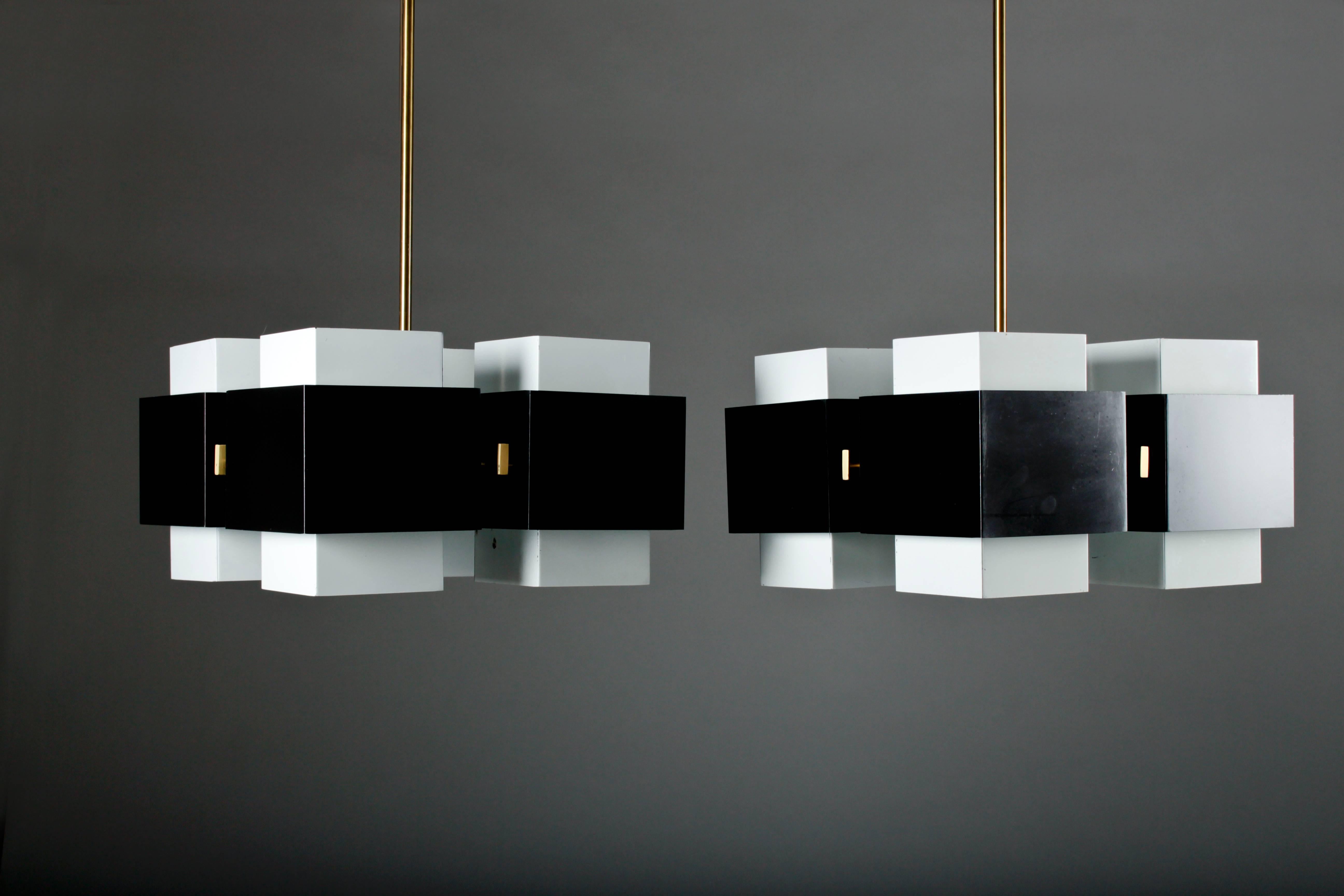 Pair of rare chandeliers by Hans-Agne Jakobsson for Markaryd in white and black painted metal, and a grounded brass inner frame and pendulum.
The pendulum can be made to desired length. (The length below -130cm- is the lamp including the pendulum.