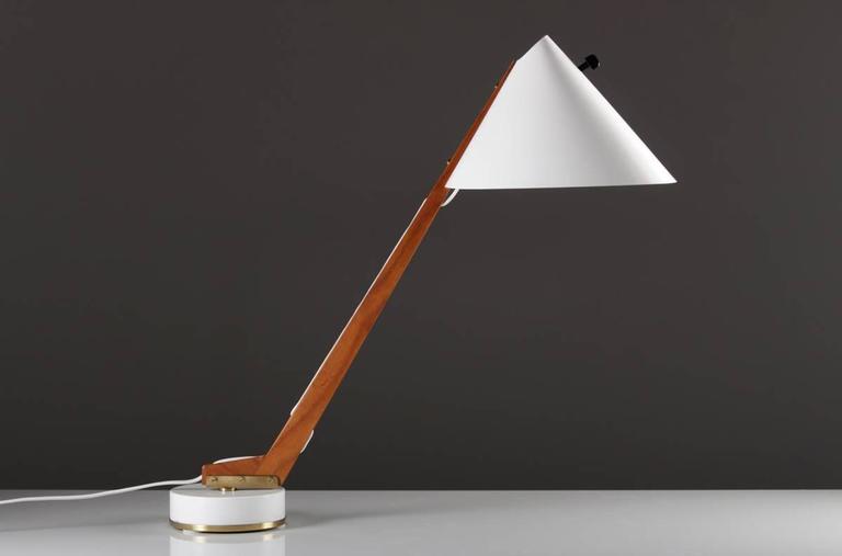 Desk lamp model G 54 by Hans-Agne Jakobsson. The lamp has a rotatable teak base with metal foot and shade and details in brass. The wire is beautifully hidden in the wood.