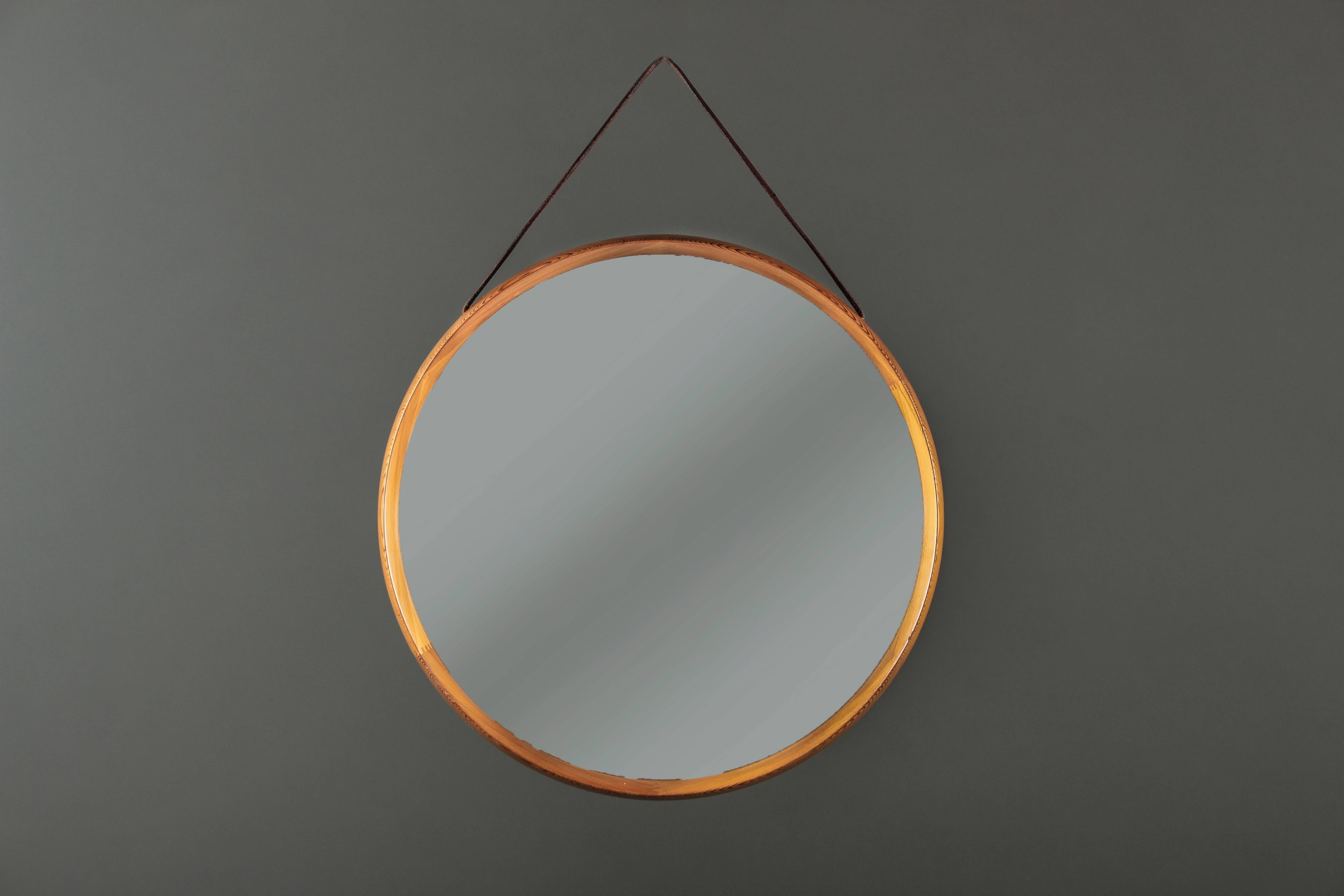 Swedish mirror by Uno & Östen Kristiansson for Luxus with leather strap. This version in pinewood rarely appears on the market.