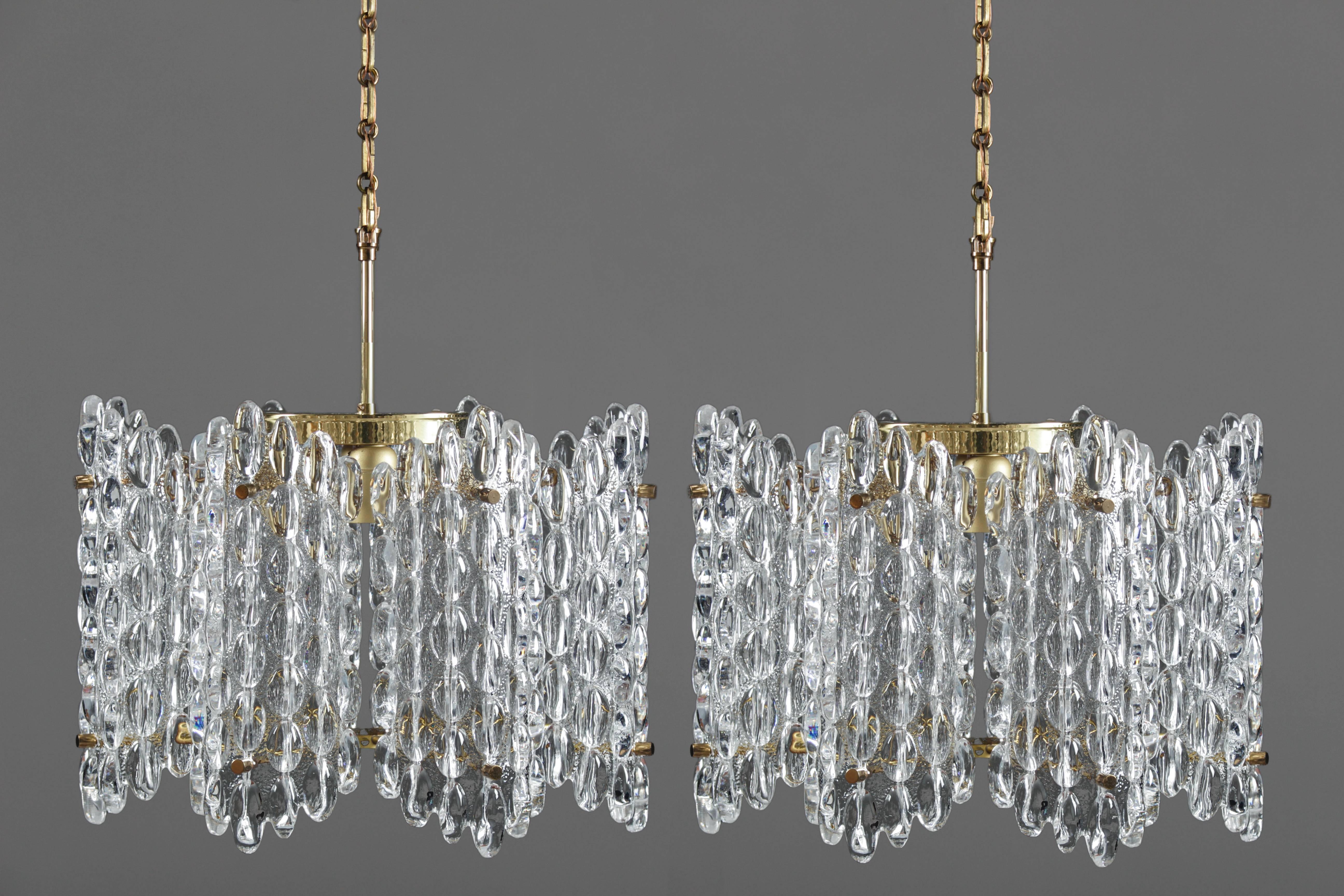 Impressive chandeliers in crystal glass and brass. The lamps feature six glass blocks separated by two brass dividers. Each lamp has four light sources and comes with original chain and canopy.
The lamps will be delivered with the glass blocks