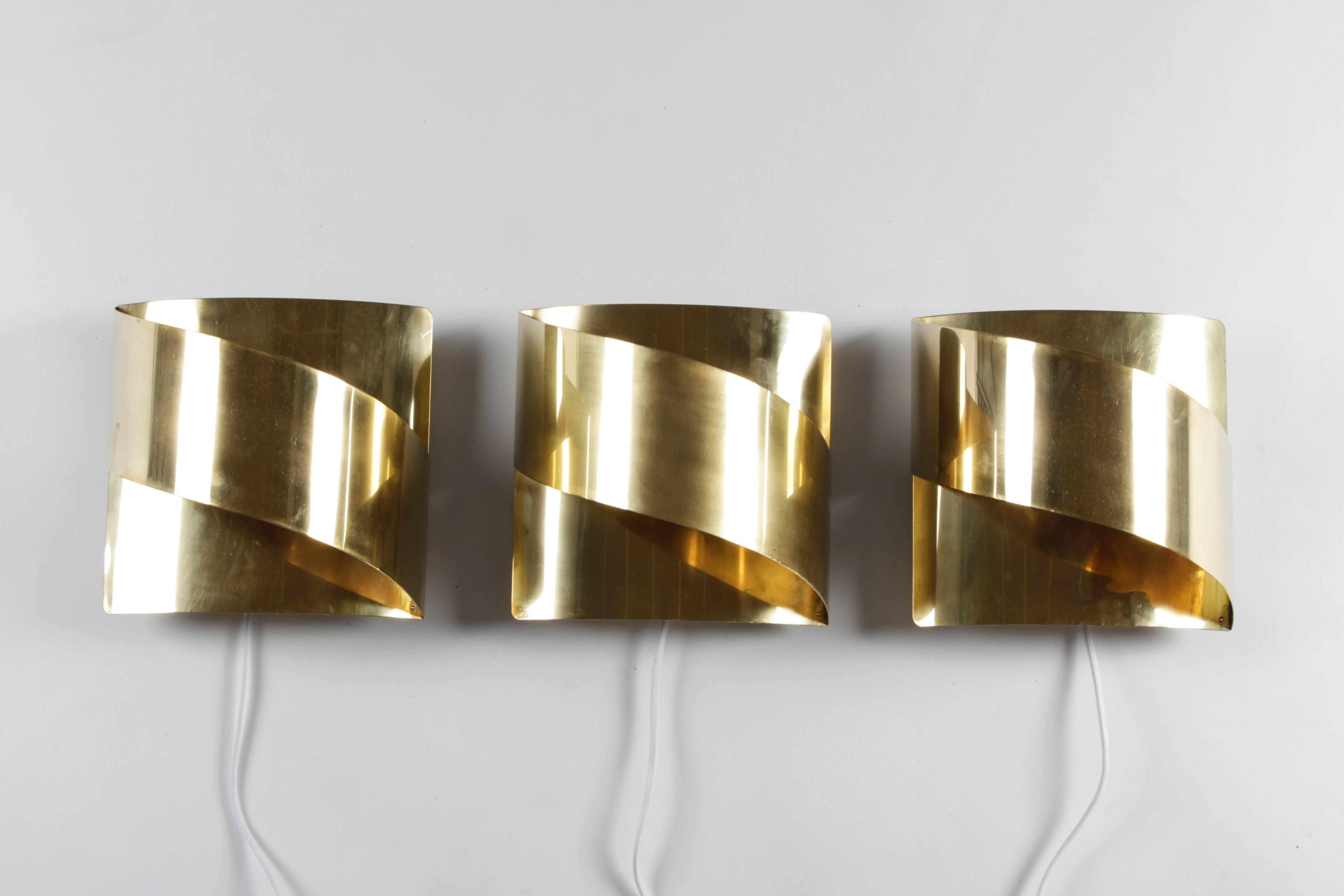 Set of three sconces by Falkenbergs Belysning, Sweden, 1970s.
The lamps feature a porcelain E 27 socket which is mounted on the wall. The brass frame is then fitted on the socket.
The lamps are in good condition with new wiring. The lacquer has