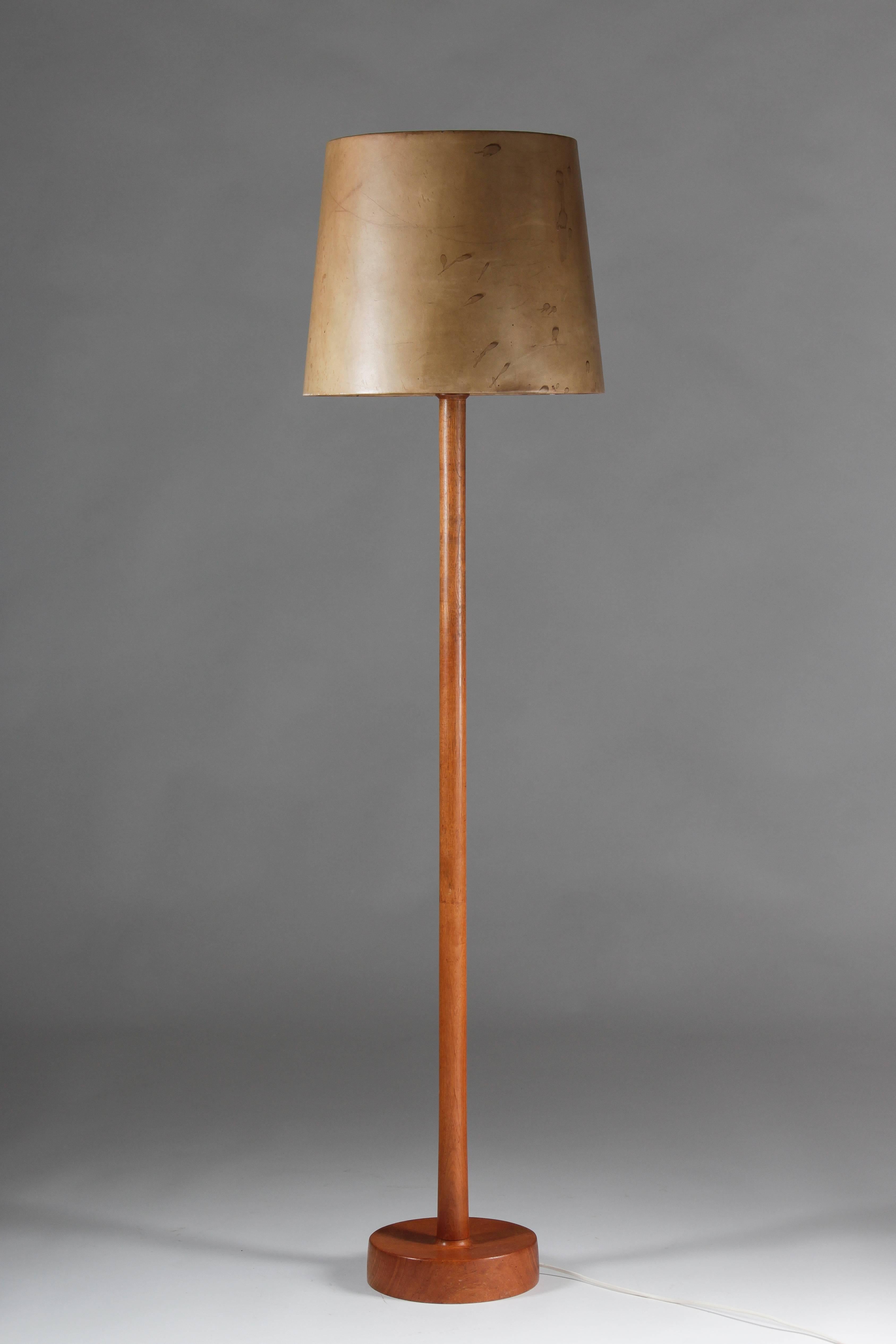 Big floor lamp in teak by Uno & Östen Kristiansson for Luxus. This lamp features a shade made of leather and showing a beautiful natural patina. As always with Luxus products, it shows great quality.