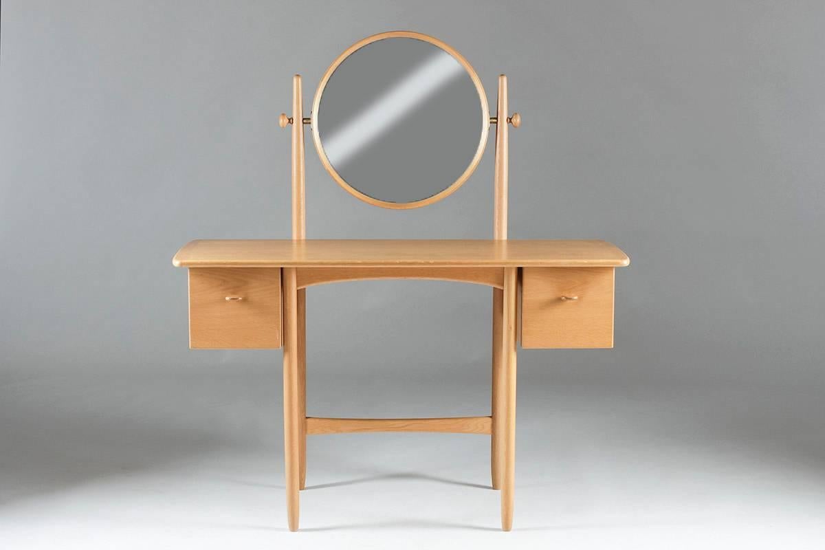 Elegant vanity table by Sven Engström and Gunnar Myrstrand in oak.
This vanity table mixes simplicity and details in an superb way. The handles on the drawers, significant for the designers furniture, the connections in the mirror frame and the