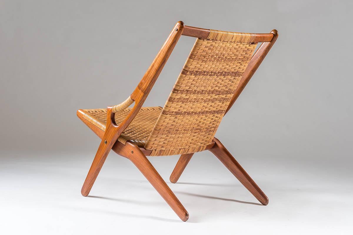 Stunning easy chair by Arne Hovmand-Olsen model 300 in teak and cane.
The frame of the chair is highlighted by two sculptural shaped pieces of wood, crossing each other on the sides of the chair. The handles are beautifully integrated with the