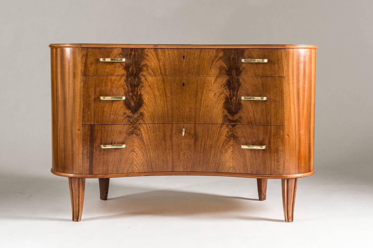 Mahogany, 1940s chest of drawers attributed to Axel Larsson by Bodafors.
Very elegant kidney-shaped chest of drawers with beautiful grain in the wood. Handles of brass that match the shape of the drawers. The backside of this piece is just as