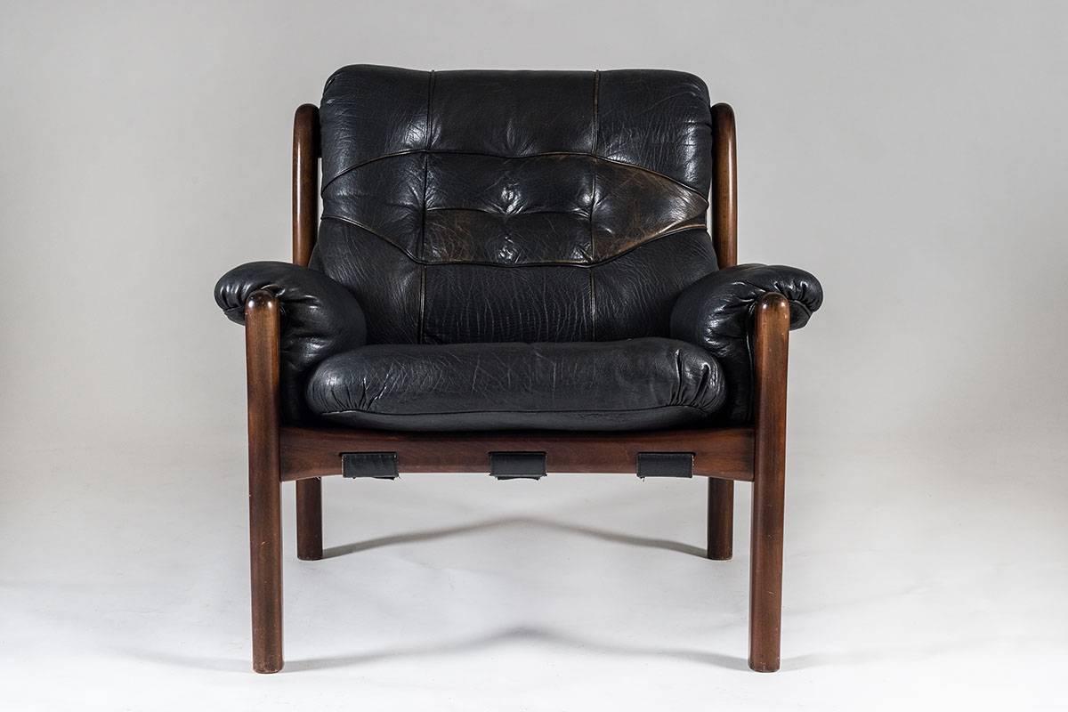 High-quality easy chair in the style of Jean Gillon, probably produced in South America.
The cushions are made of black buffalo leather and rest on thick fabric, attached by leather straps. The frame is made of dark stained beech.
Condition: Very