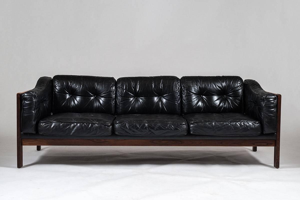 Top-quality sofas designed by Ingvar Stockum for Futura Möbler in 1965. This sofa was only in production for two years because production costs were too high. This luxury version with its frame made of solid rosewood and black leather cushions