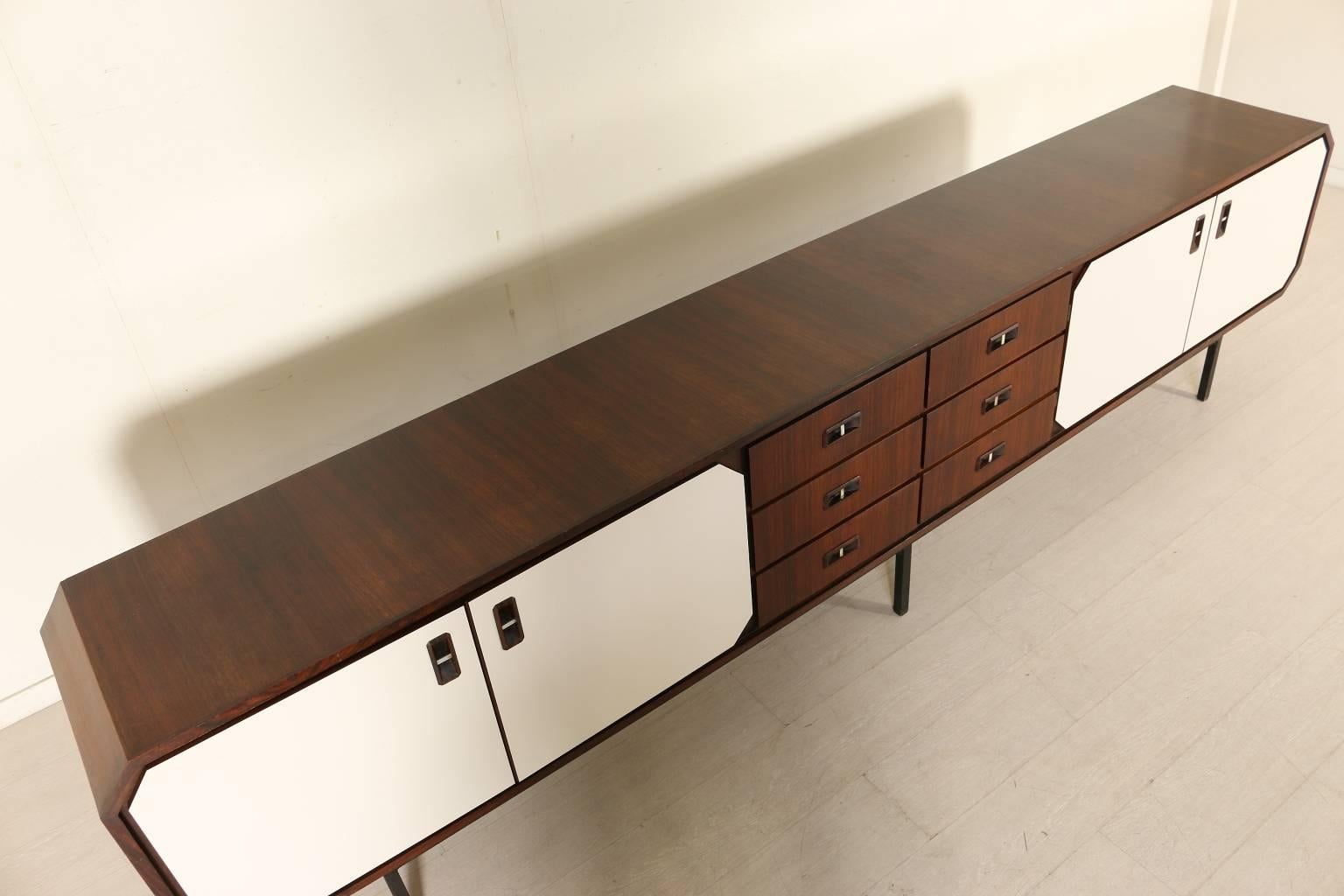A sideboard, rosewood veneer, doors covered with Formica, metal legs. Manufactured in Italy, 1950s-1960s.