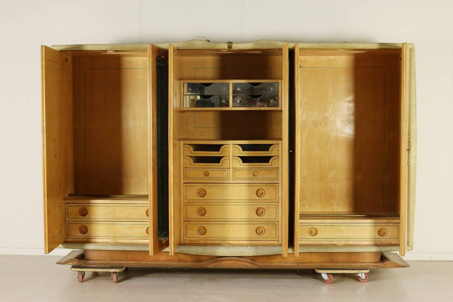 A six doors wardrobe, burl veneer, decorated mirror, carved and lacquered frame, brass details. Manufactured in Italy, 1930s.