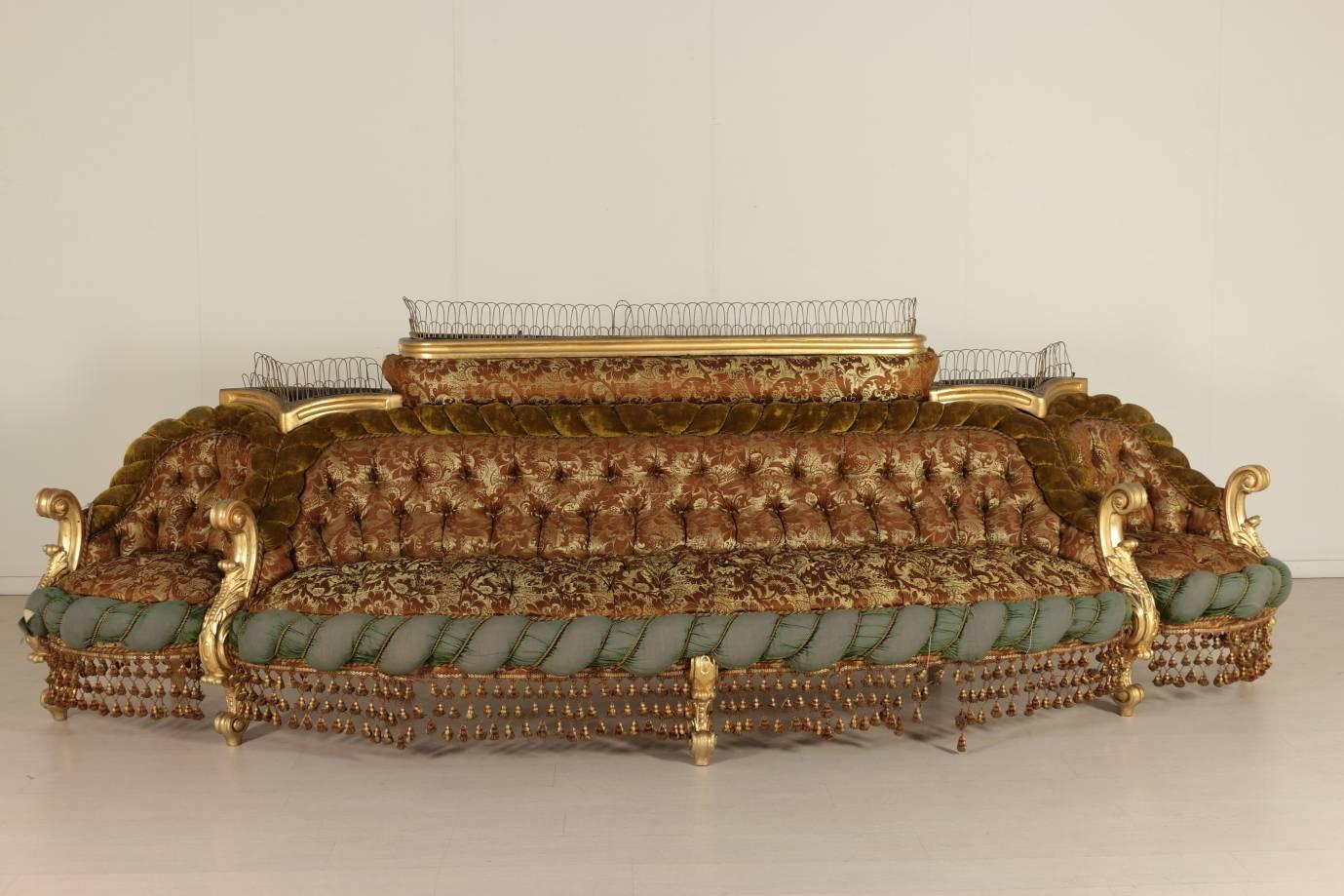 A late 19th century Baroque style padded sitting room. Carved and gilded wood. Refined capitonné velvet and satin damasked padding with fringes. Includes: Pair of armchairs (85 x 72 x 60), group of four chairs (91 x 65 x 53), corner sofa (100 x