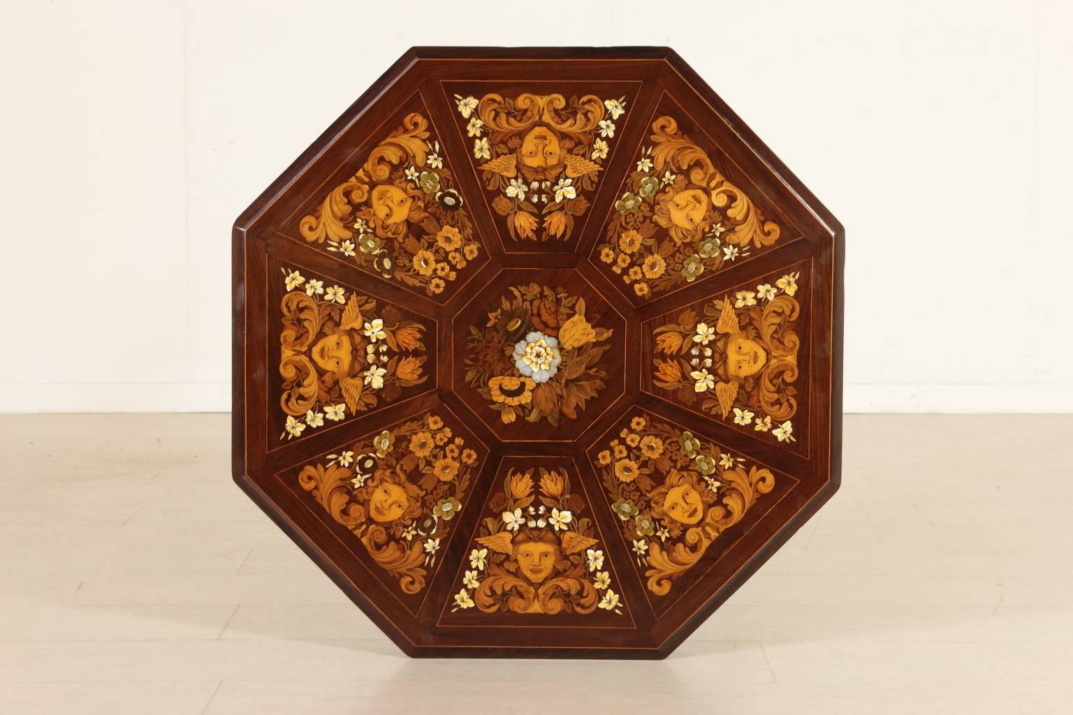 A 19th century coffee table with four shaped legs joined in a turned basket. Octagonal walnut veneered carved band. Chestnut octagonal top, rosewood veneered with inlays of various woods, ivory and nacre. The inlaid decorations are distributed in