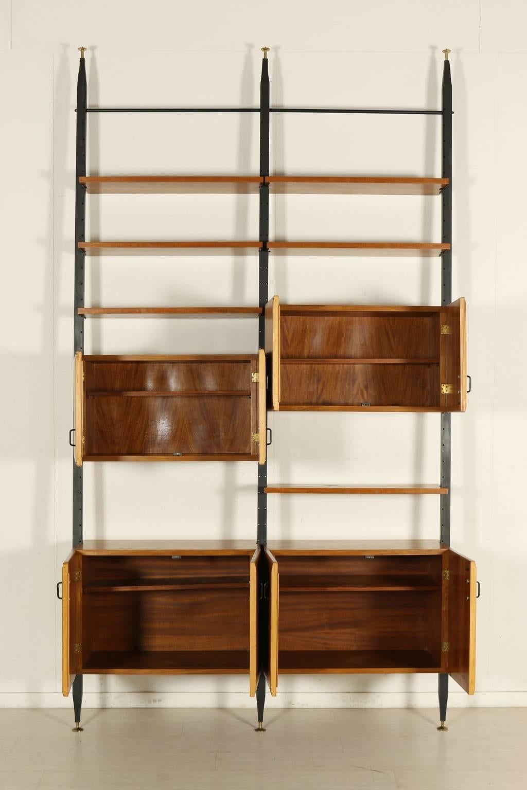 A floor-to-ceiling bookcase with elements adjustable in height, teak veneer, metal. Manufactured in Italy, 1950s.