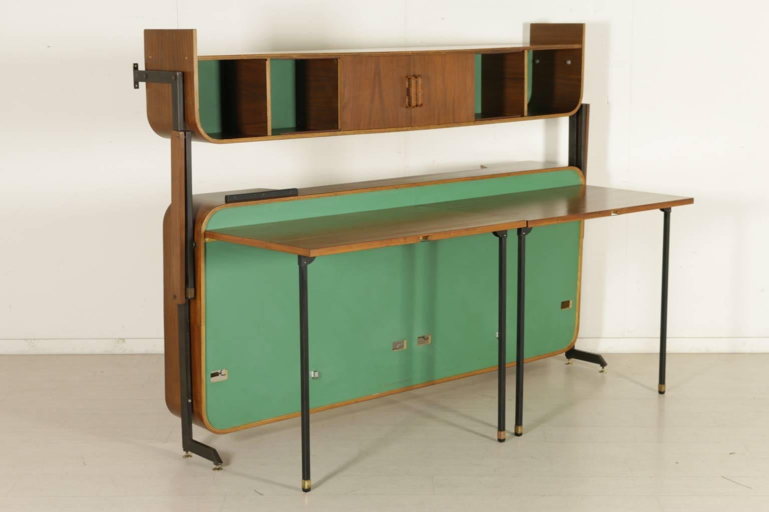 A bed-cabinet attributed to Franco Campo, convertible into a study with two desks. Mahogany veneered bent plywood with lacquered details, varnished metal, brass. Manufactured in Italy, 1950s.
