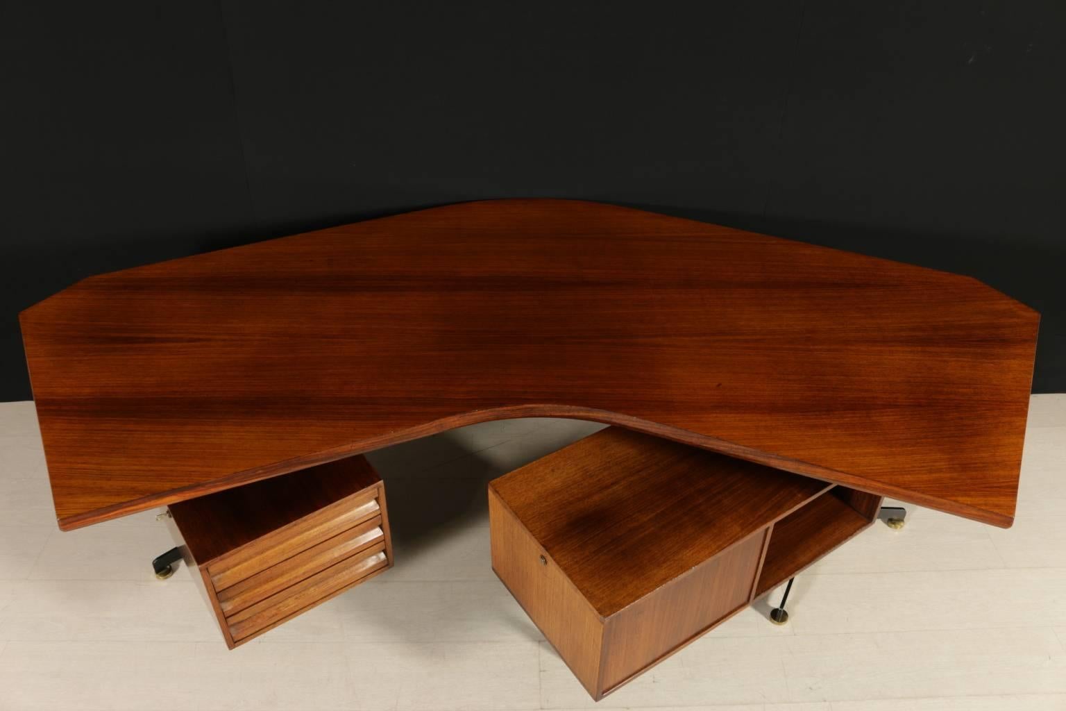 A desk with swiveling chest of drawers designed by Osvaldo Borsani, model T96. Rosewood veneer, lacquered metal structure with adjustable brass feet. Manufactured in Italy, 1950s-1960s. The desk was designed in 1956 for ENI furnishing in San Donato