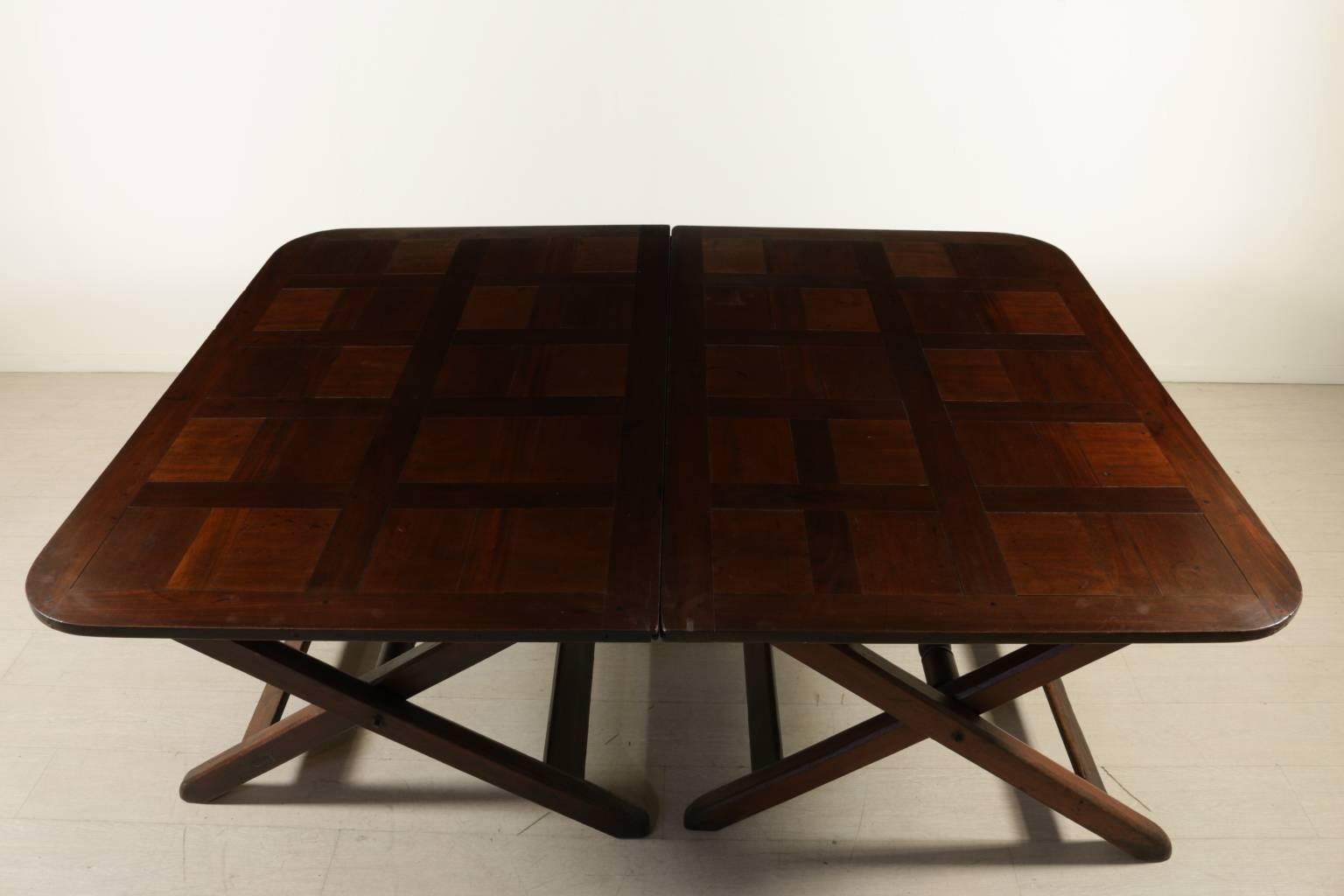 A pair of 18th century English mahogany trestle tables joined in one single top. Tresle supports linked by a longitudinal turned cross-member. Elegant solid mahogany top.