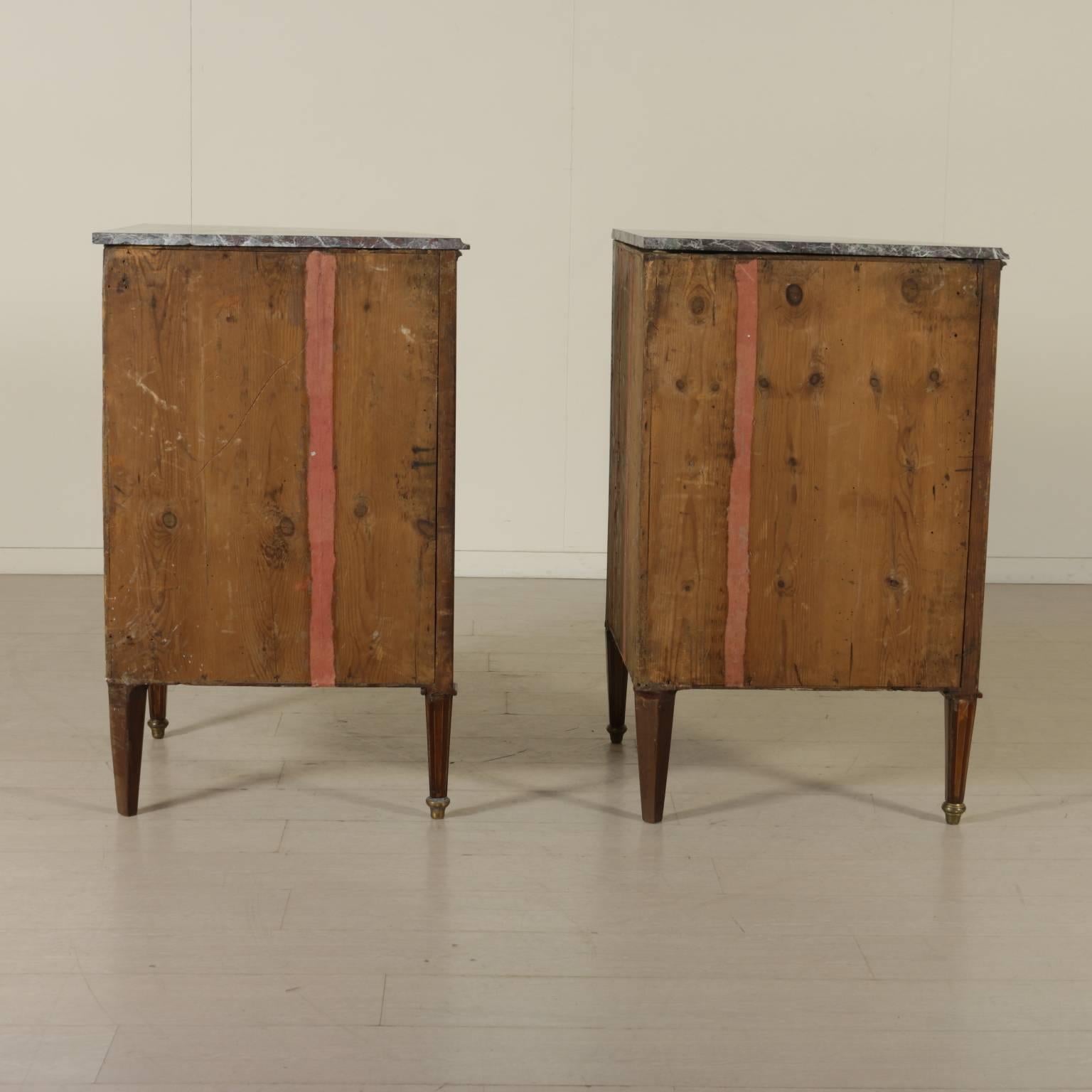 A pair of late 18th century neoclassical Italian corner cabinets with bent front, made of one door, breccia top, and truncated conical feet. Rosewood veneer, central coat of arms with crowned eagle, containing other two coat of arms (Imperial family