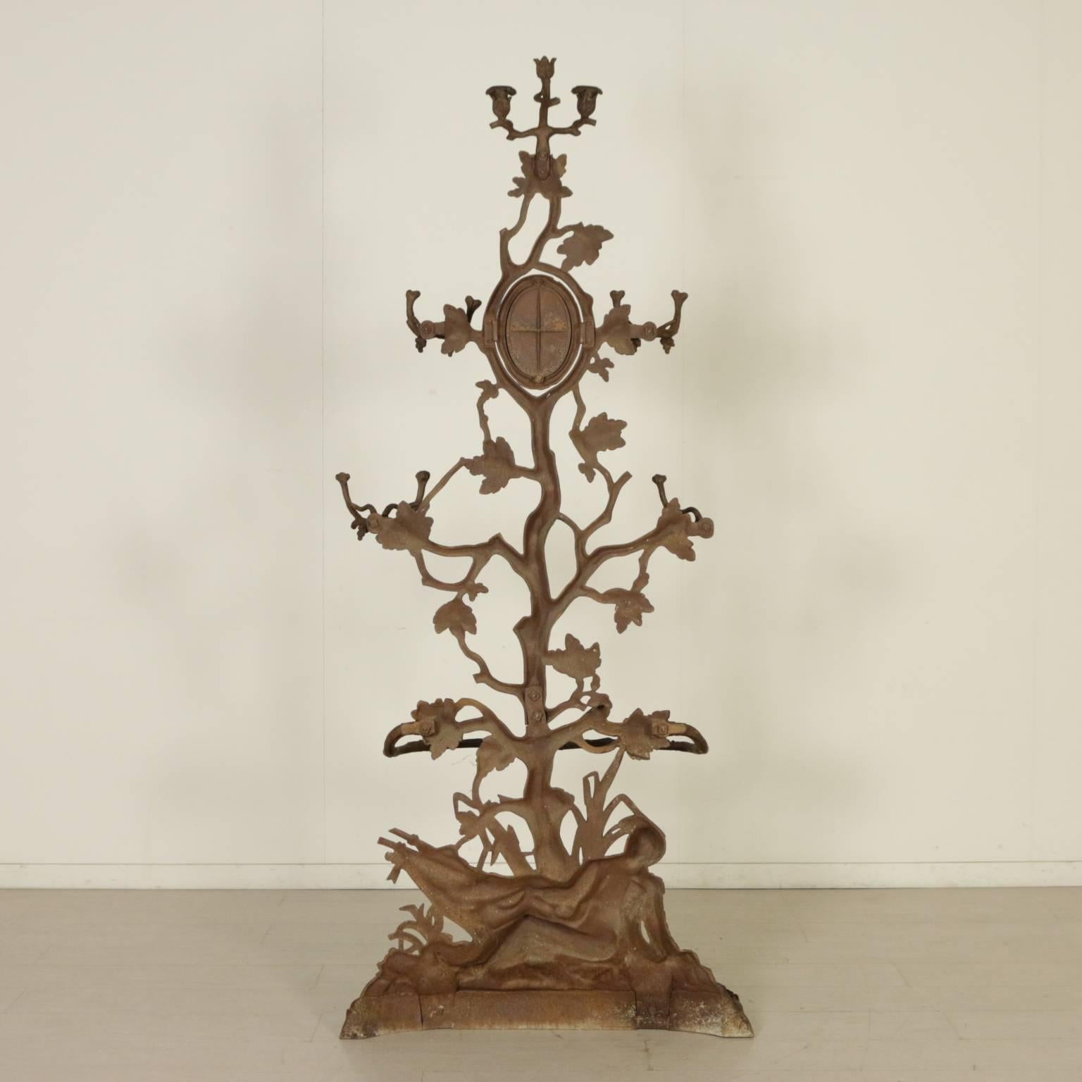 A cast iron coat hanger, oak tree shape with leaves, acorns and lying soldier. In the middle, a tilting oval mirror and candlesticks. Umbrella stand with enamelled tubs. Marked Corneau Freres A Carleville n° 287. Manufactured in France, late 19th