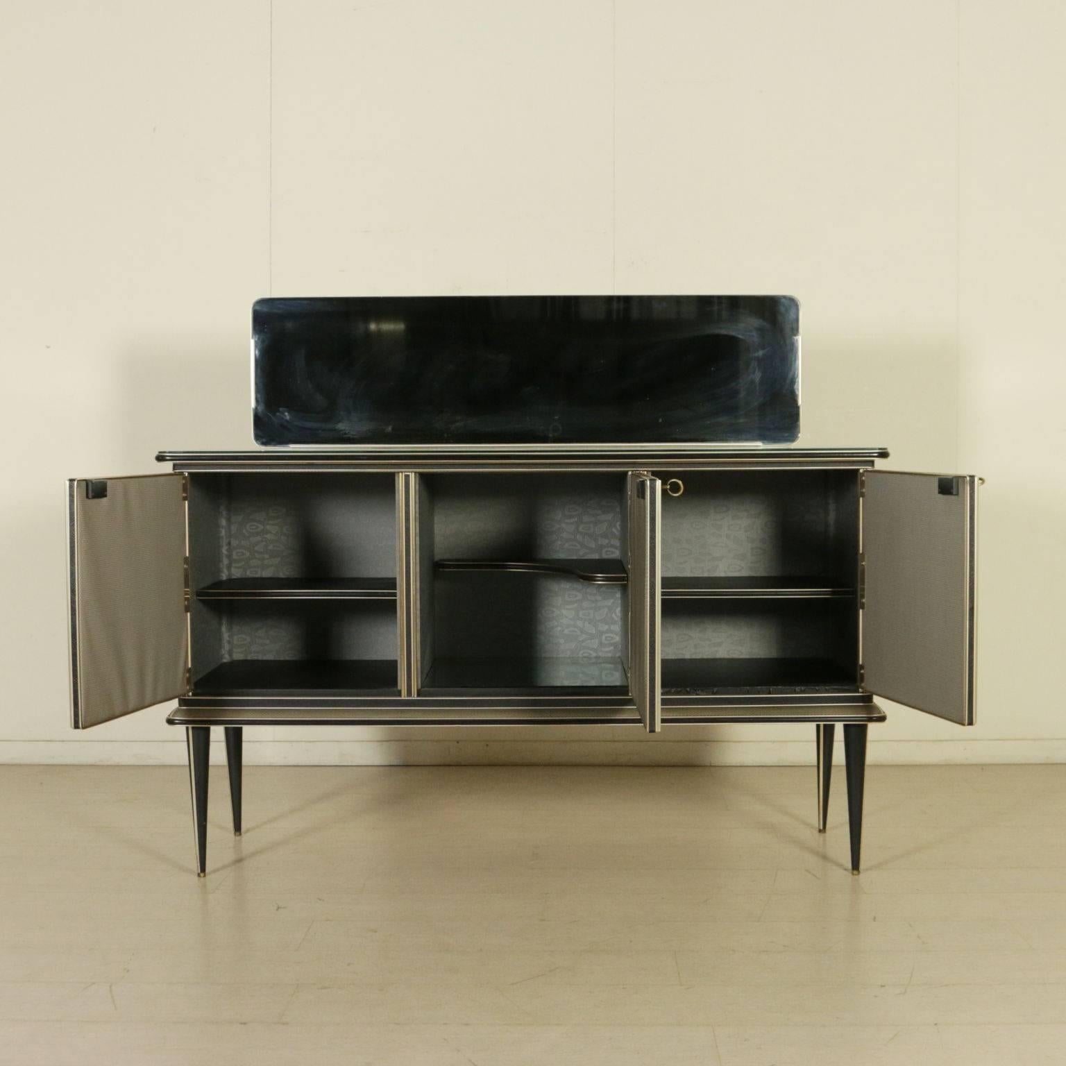 A sideboard with mirror, wooden structure covered with quilted skai, decorated glasses on the doors, protective glass on the top. Manufactured in Italy, 1950s.