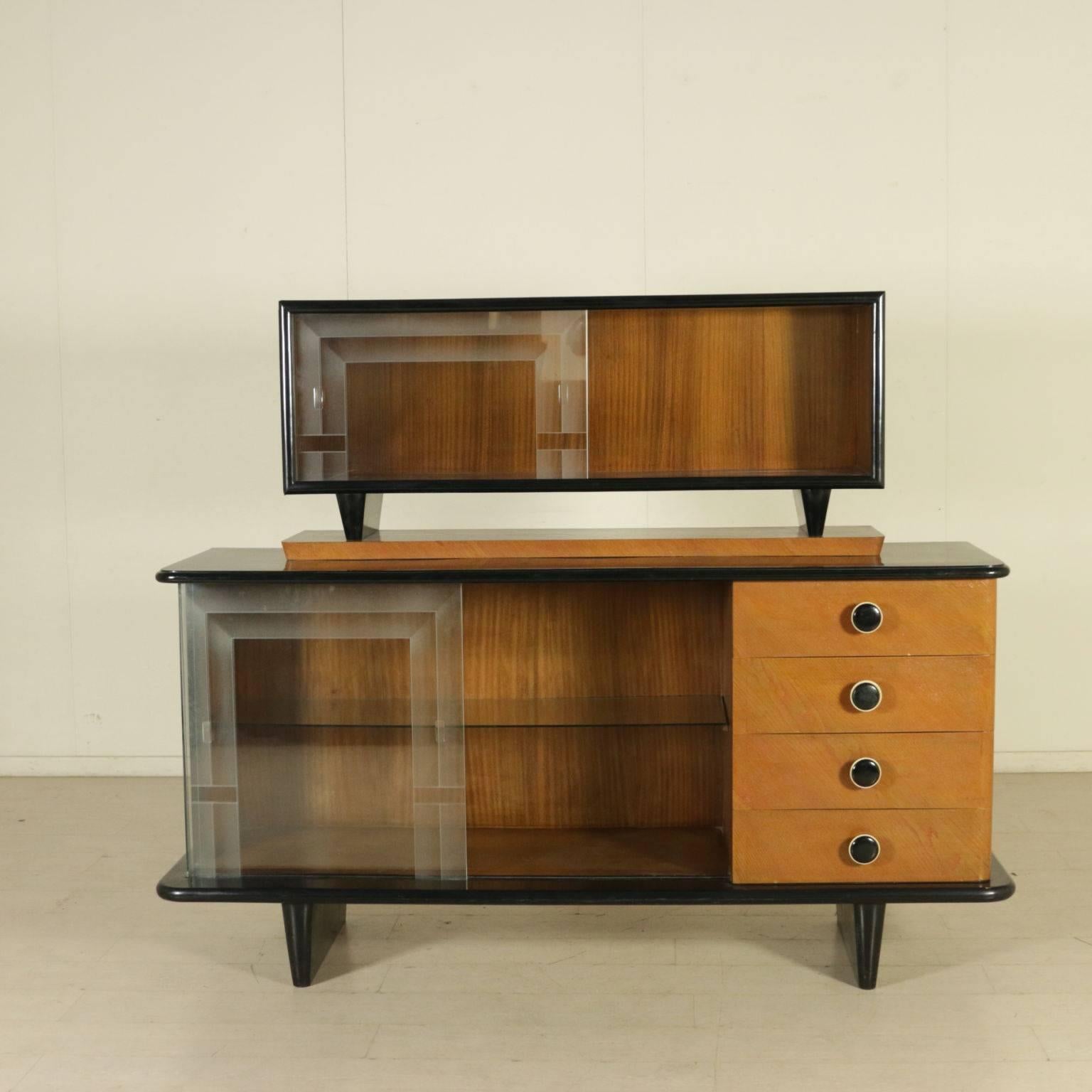 A sideboard with raised top and glass sliding doors. Ash veneer, ebony stained veneer. Manufactured in Italy, 1940s.