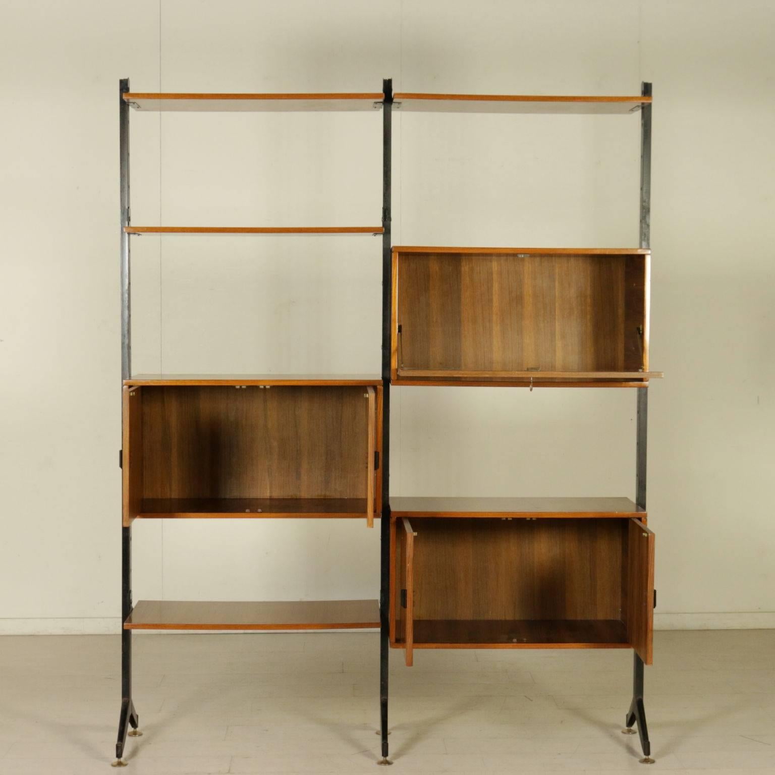 A bookcase with elements adjustable in height, metal uprights, brass, teak veneered wood. Manufactured in Italy, 1950s-1960s.