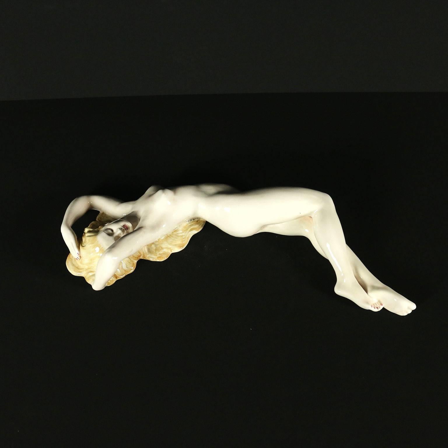 Enamelled ceramic sculpture depicting a female naked. Manufacturing brand on the back in the bottom.