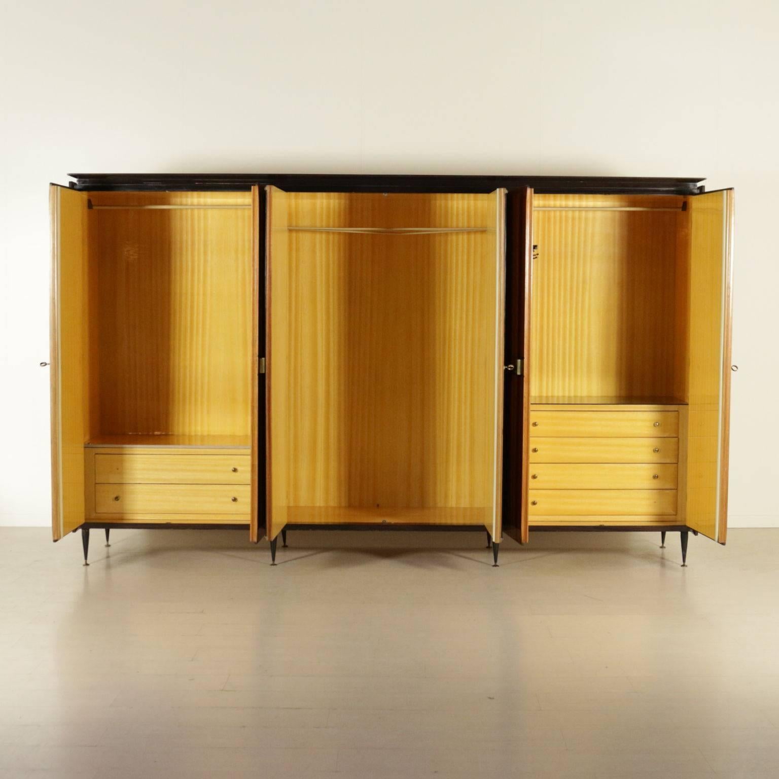 A wardrobe with six hinged doors, rosewood veneer, mirrors, brass handles, metal legs. Manufactured in Italy, 1950s-1960s.