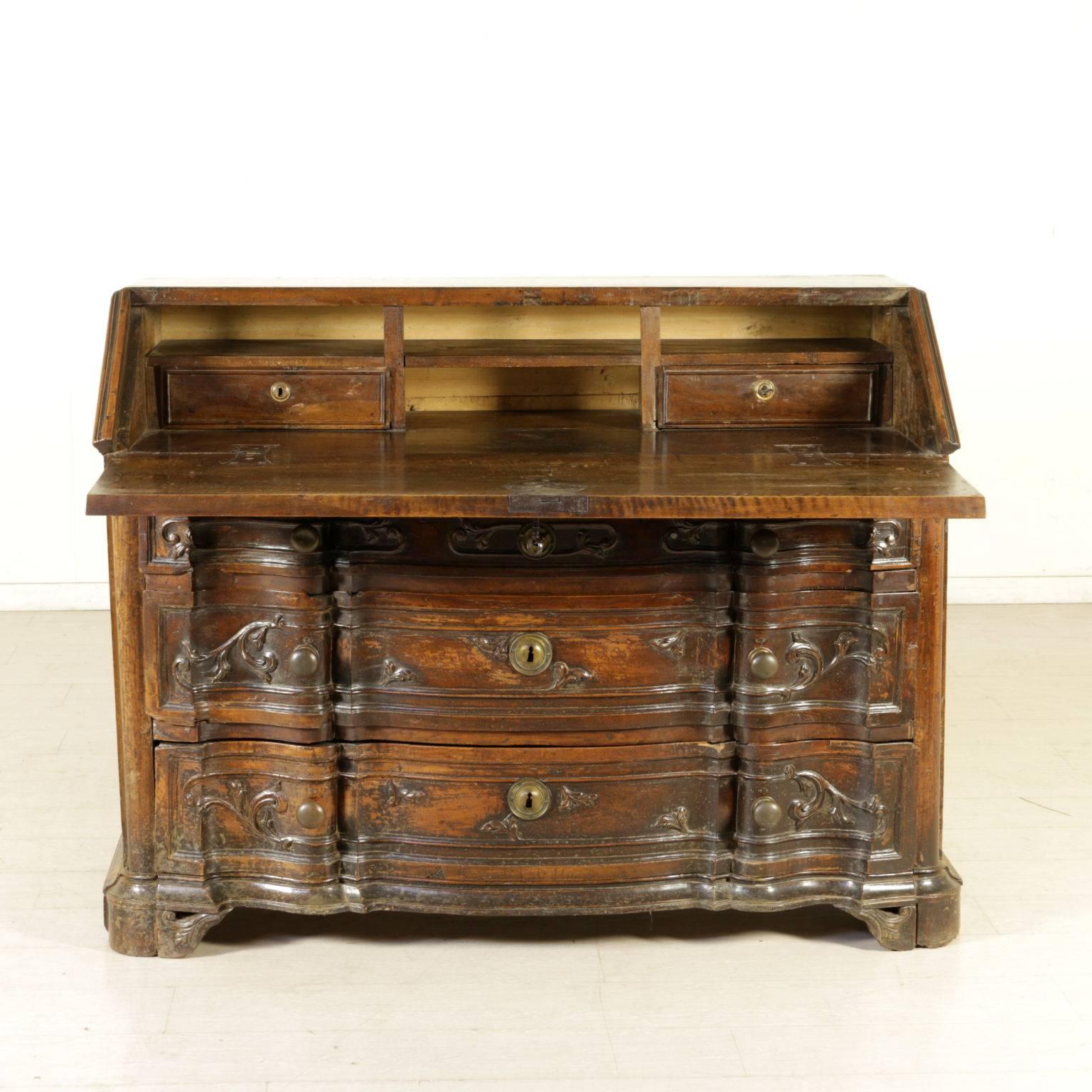 Drop-leaf secretaire with crossbow front, three drawers and leaf door. Two drawers and compartments inside. Magnificently carved volutes on the front and the sides, bracket feet. Manufactured in Matua, Italy, 18th century.