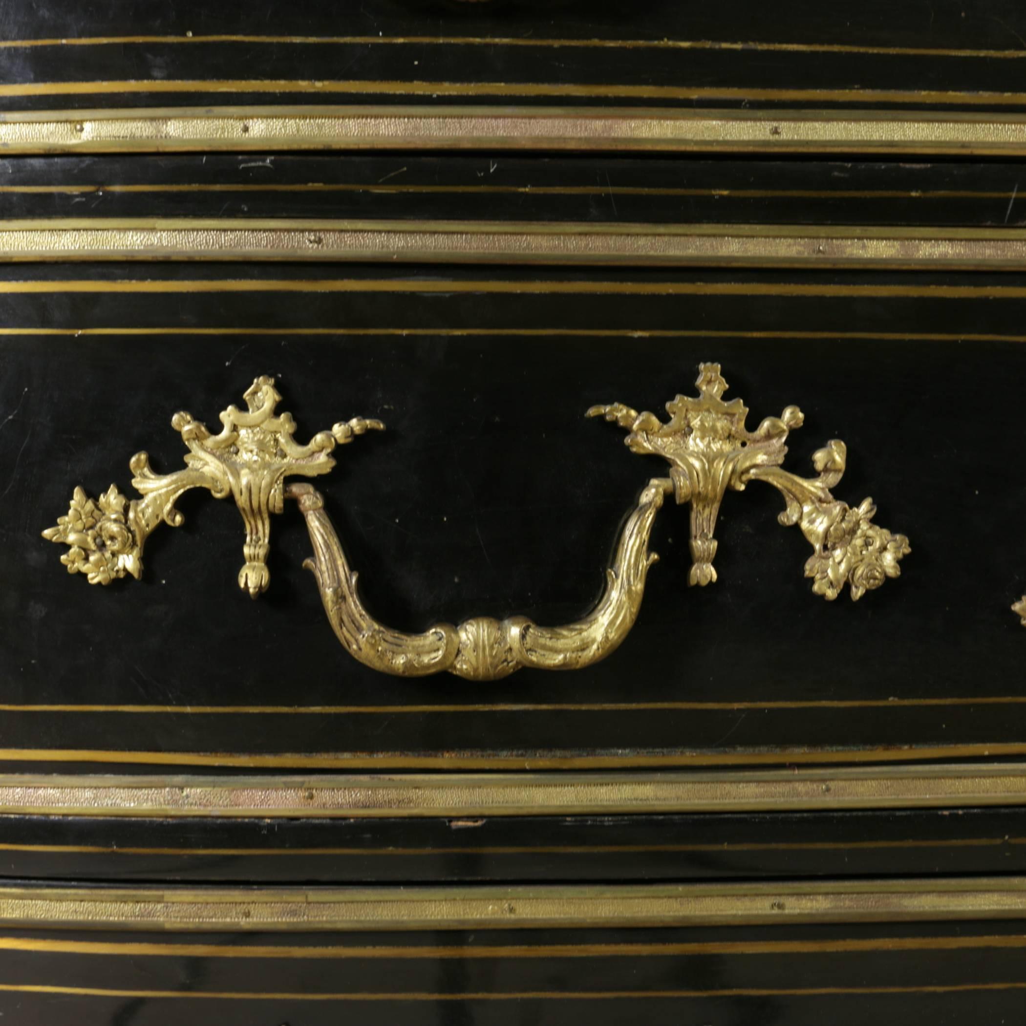 Commode with three drawers, curved on the face, in the flanks, a-pillars in relief; the floor in the crack black. The entire surface is veneered in ebony, the three drawers are profiled by frame in gilded bronze, chiselled, also the plinth of the