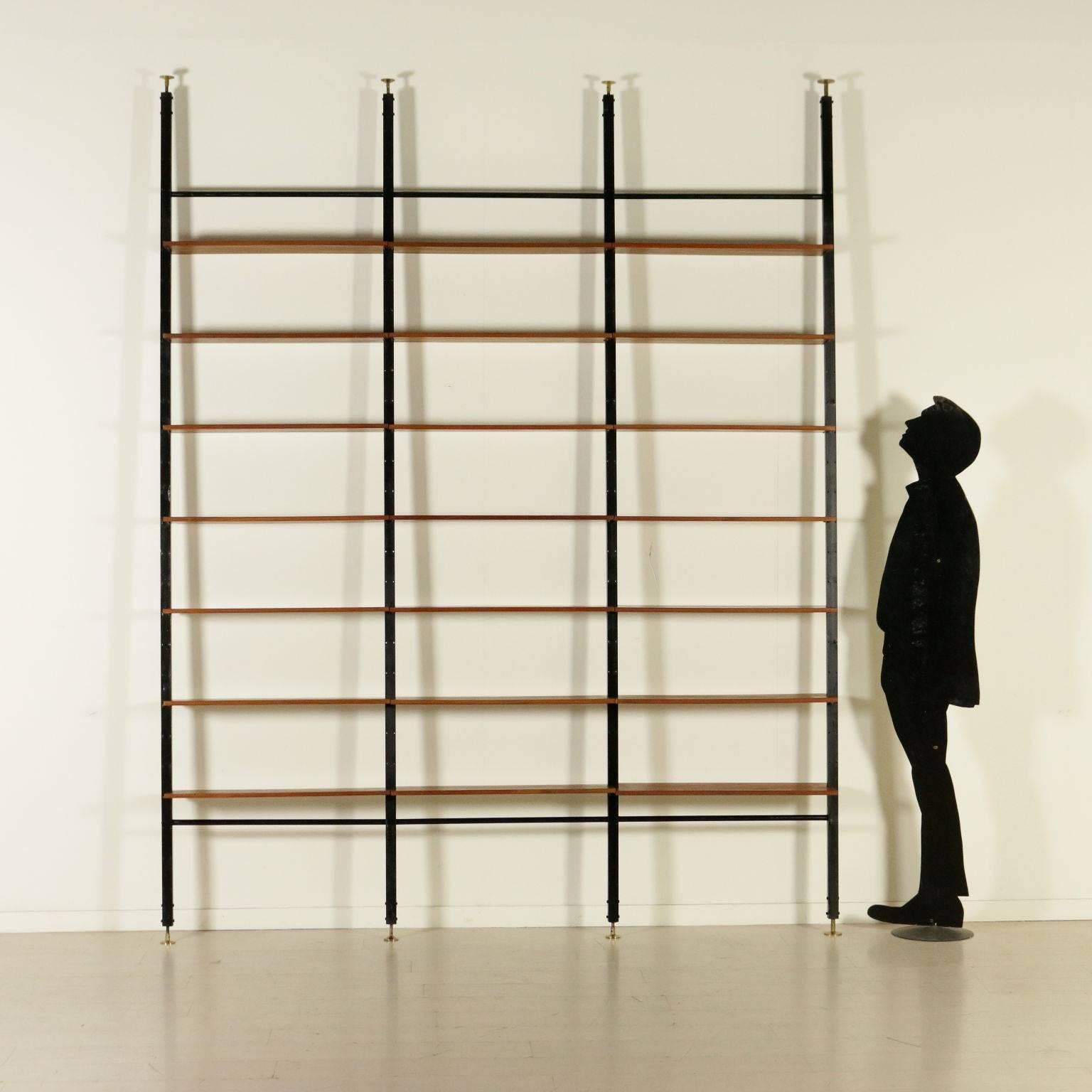 A floor-to-ceiling bookcase with extendable uprights and adjustable shelves in height. Metal uprights with brass ferrules and teak veneered shelves. Manufactured in Italy, 1950s-1960s.