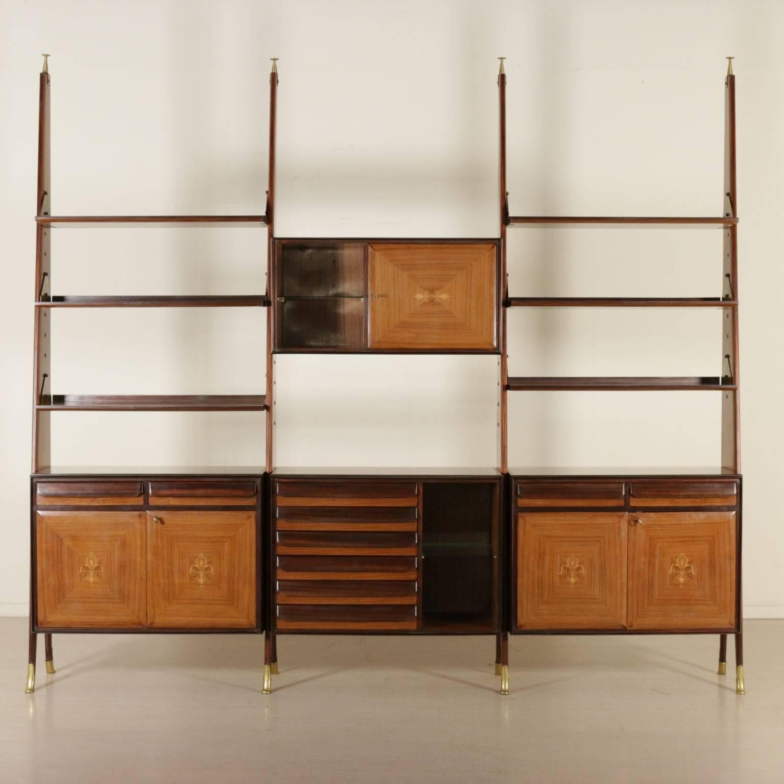 A bookcase with adjustable shelves in height and containers. Rosewood veneer with inlaid decorations, brass. Manufactured in Italy, 1950s-1960s.
