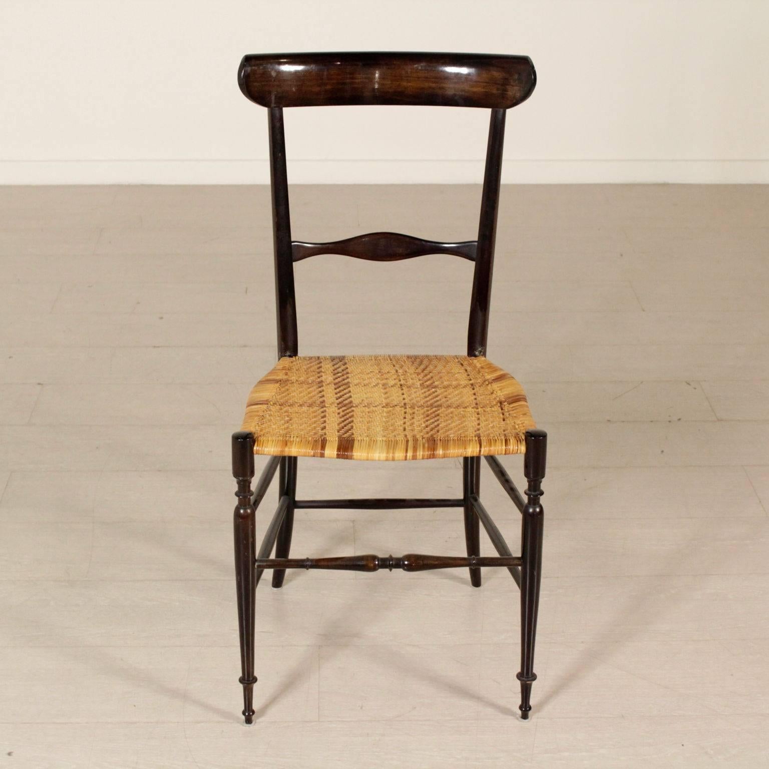 A group of four chairs, lacquered wood, intertwined rattan. Manufactured in Italy, 1950s-1960s.