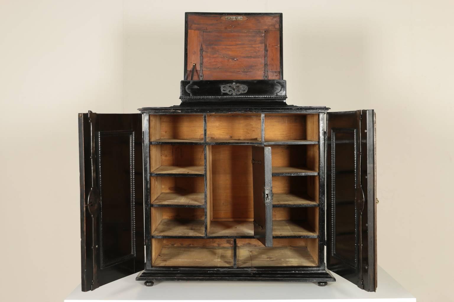 A 19th Century coin cabinet with two doors and pillar stiles. Upstand on the top and opening lid. The cabinet is enriched by guilloche frames, wrought iron side handles, elegant bronze hinges. Ebonised on the whole surface. Manufactured in Veneto
