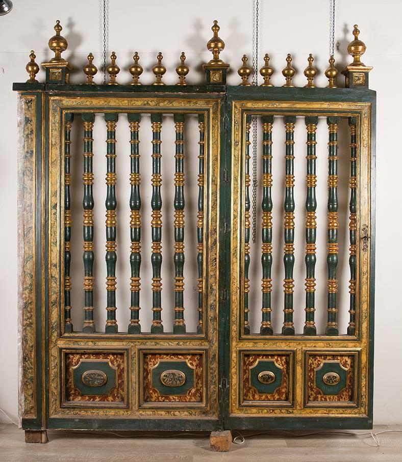 Important church gate in carved, polychrome and gilded wood. 17th century.
Double door with four leaves, decorated on both sides with polychromy of green hue and marbling in ocher, bluish and green. With it's original key.
Measures: 252 x 221 cm.