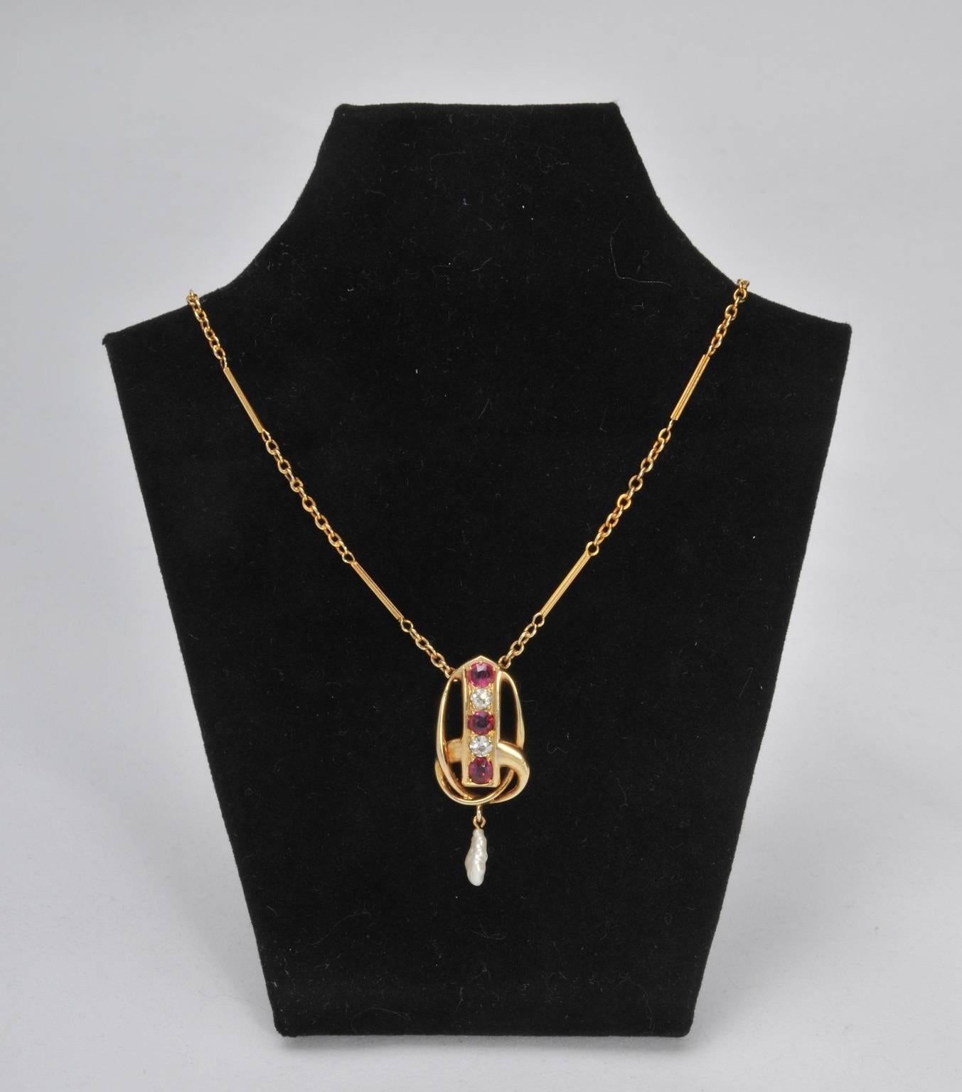 A stunning diamond and ruby 15ct gold pendant by Archibald Knox for Liberty & Co.  A variant of a pendant design like this can be seen in the Liberty sketch book and was sold previously by Tadema Gallery; Liberty sketch number 870.
