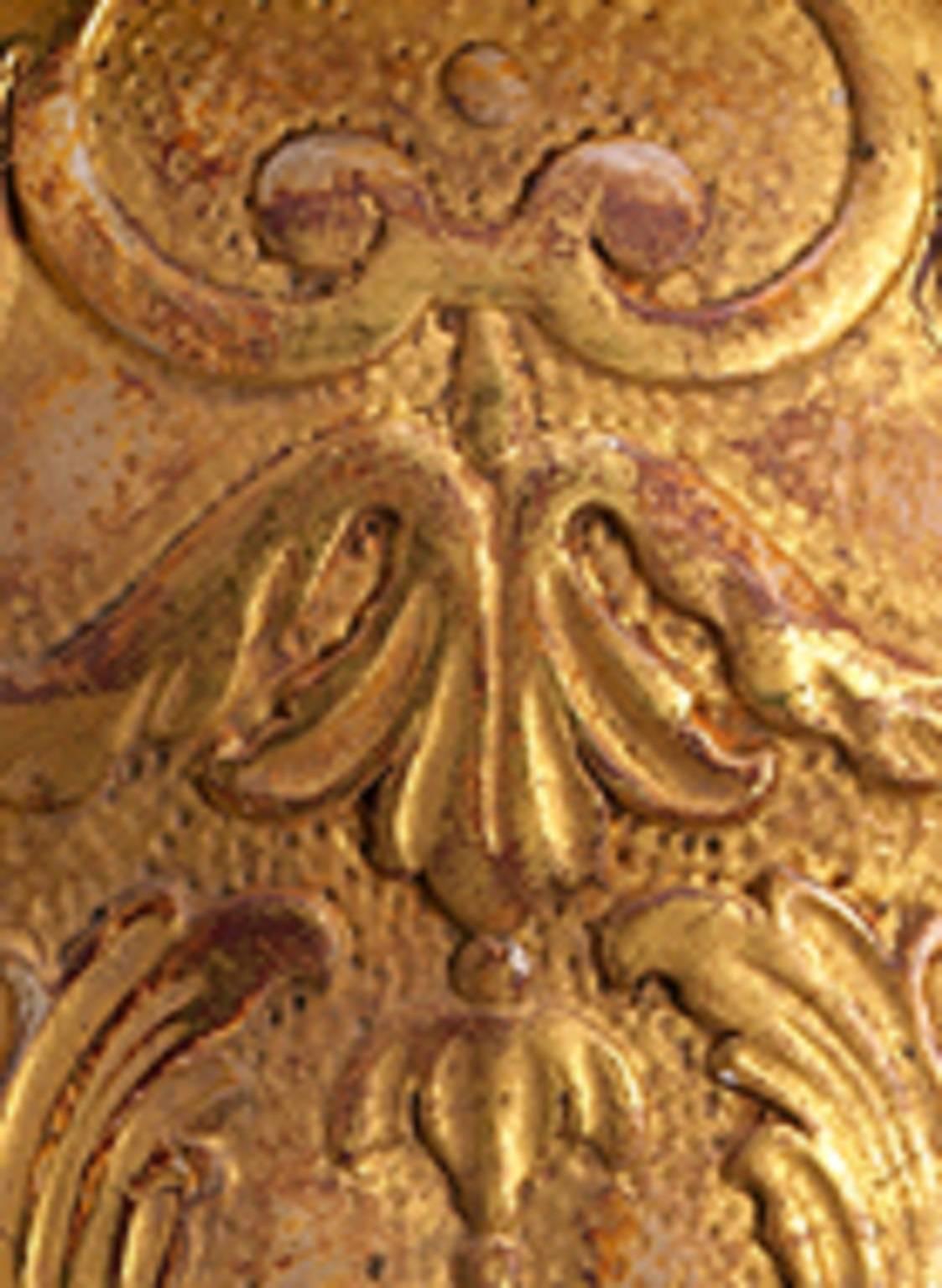 These carved gilded wood wall lights in the style of George II and the 1730s, are in the form of cartouches. Fitted with a leaf cast, scrolling candle arm, they are decorated with vigorous acanthus leaf scrolls and masks.