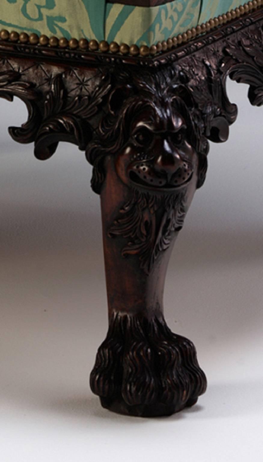 Paire de chaises de bibliothèque en acajou de style George II, abondamment sculptées, avec des accoudoirs en forme de tête de lion, des rinceaux de feuilles d'acanthe et des cartouches feuillagés. Les pieds cabriole avec des masques de lions