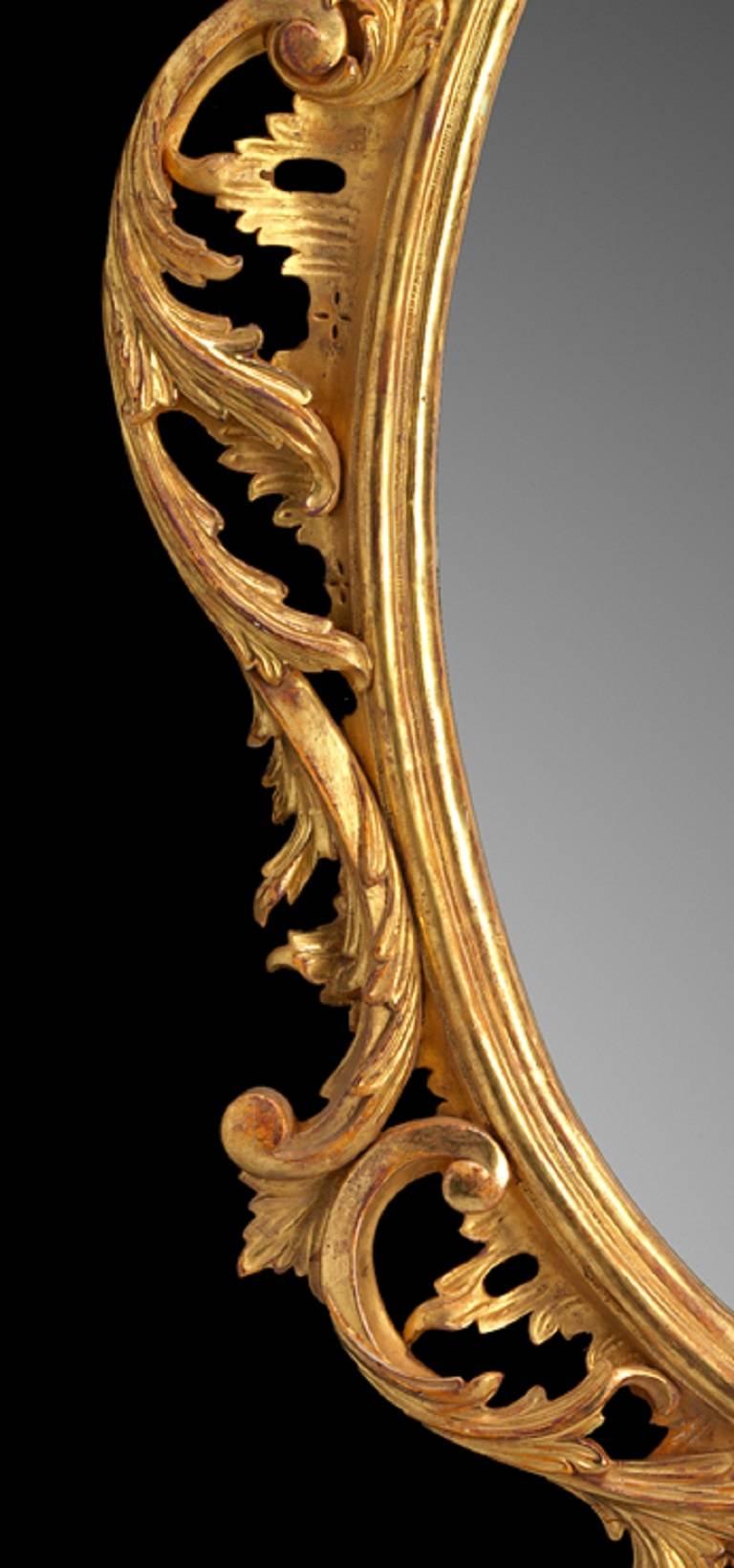 A George III Chippendale design carved giltwood oval mirror, the moulded frame carved with cabochon and intertwined ‘C’ scrolls and acanthus leaf spray.

We are currently working to a 30-36 week lead time.