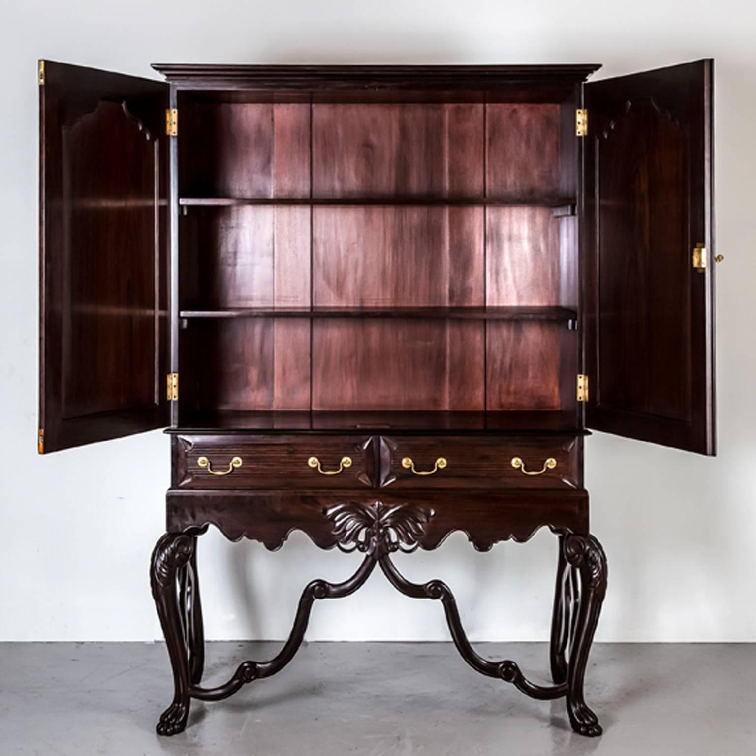 A magnificent Portuguese colonial rosewood cupboard on stand with an overhanging rectangular top. 
The double doors are crafted with an arched cushion moulded panel and with a pattern exclusive to Portuguese India. The doors open to an interior
